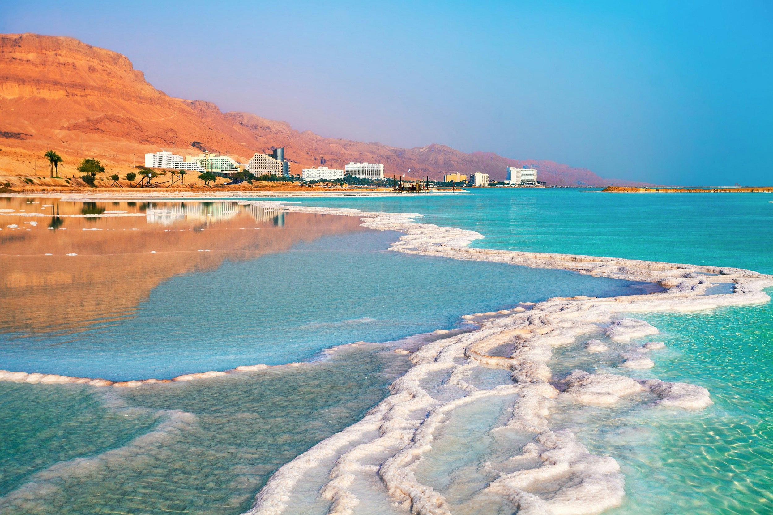 A line of gleaming white salt crystals protrude from the Dead Sea near the shoreline at Ein-Bokek. 