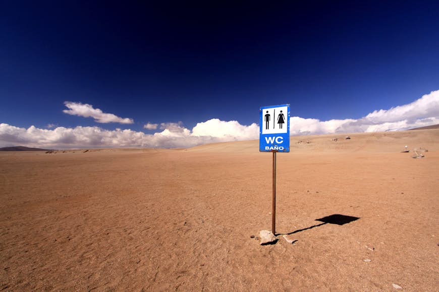 A sign reading "WC" in the middle of a red desert