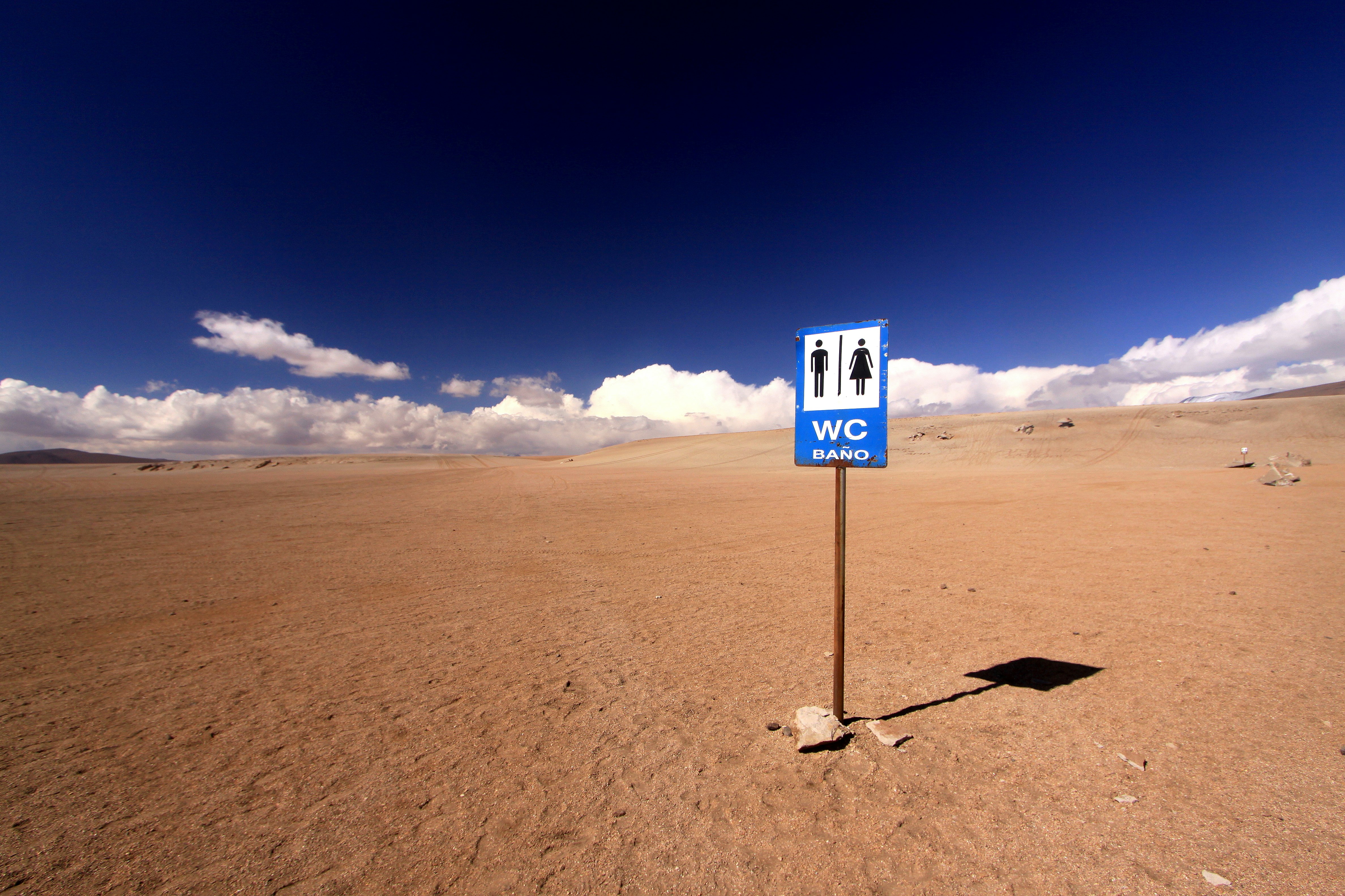 A sign reading "WC" in the middle of a red desert