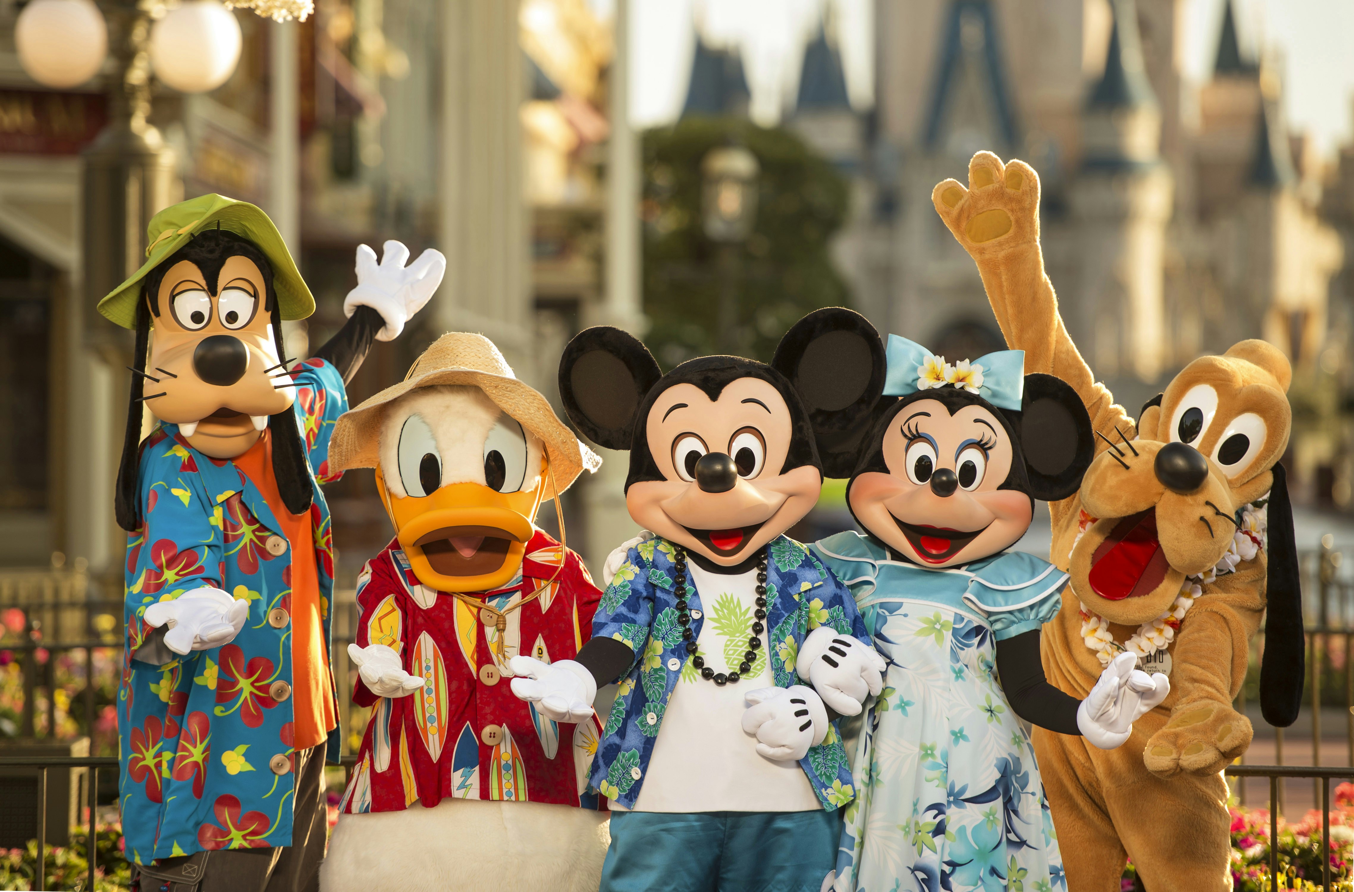 Costumed characters of Goofy, Donald Duck, Mickey Mouse, Minnie Mouse and Pluto stand together at a Disney park
