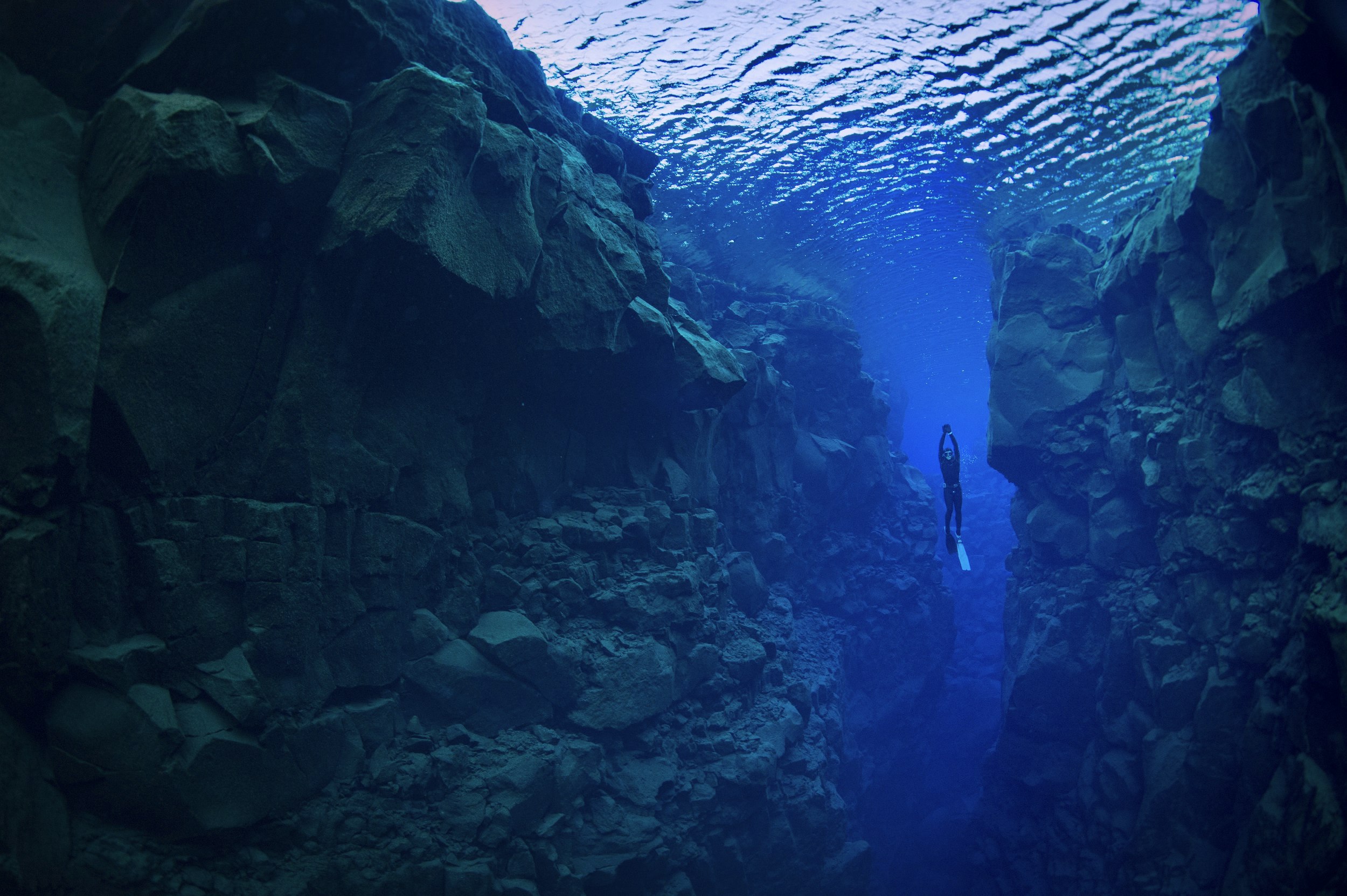 A free diver ascends up the narrow Silfra Fissure, which separates two continental plates.