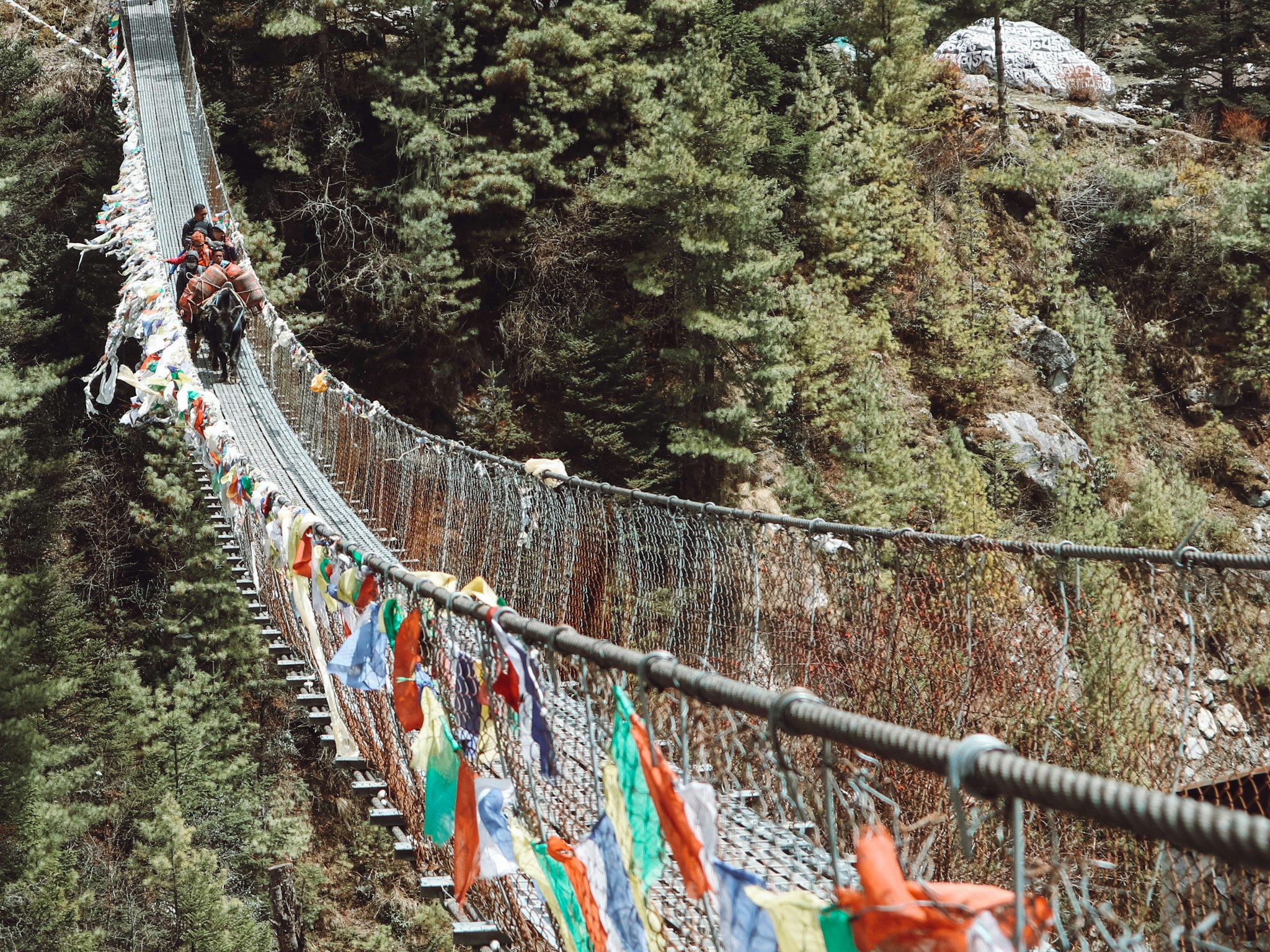 Trekkers cross one of several suspension bridges along the Everest Base Camp trek