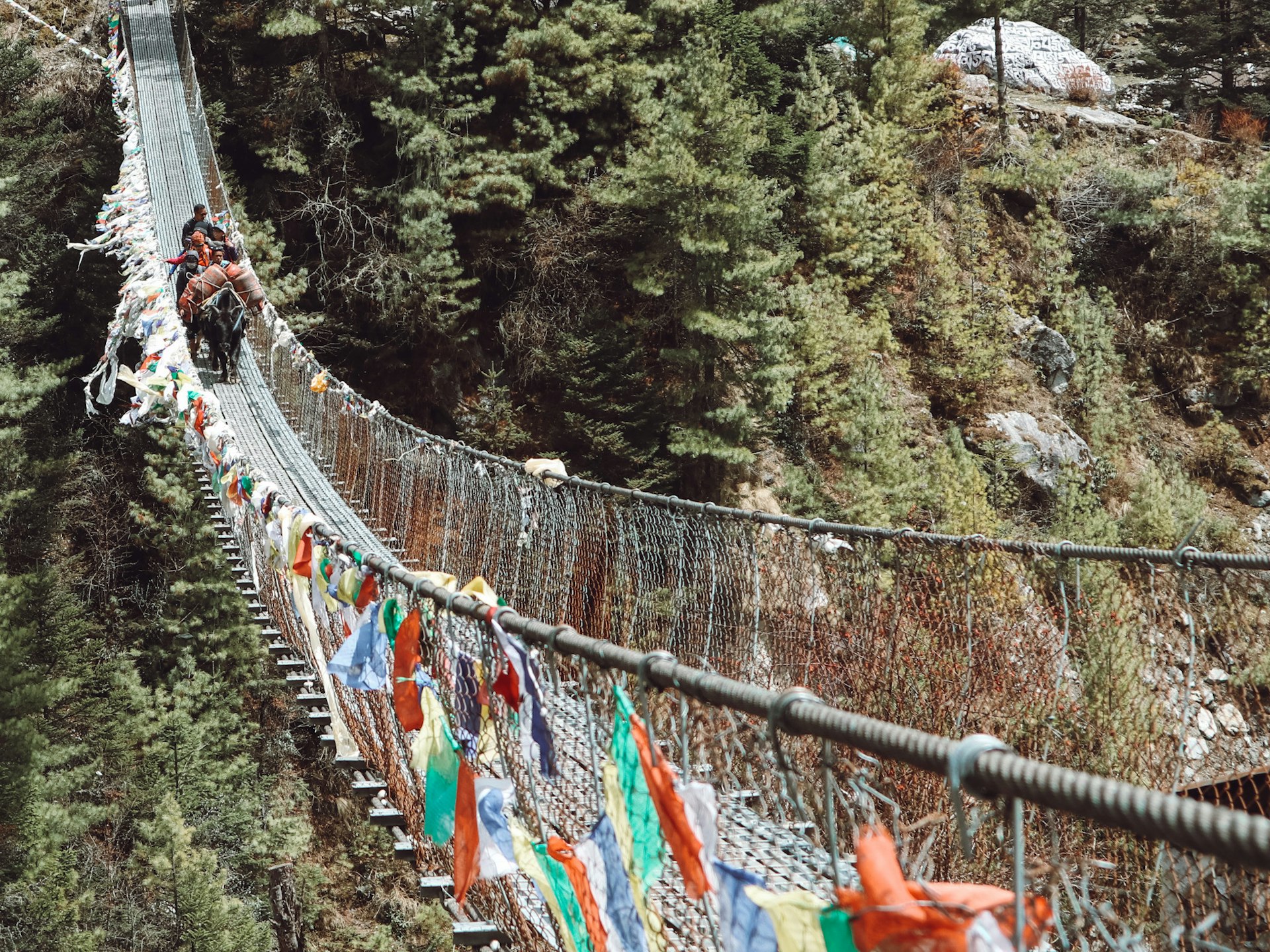 Trekkers cross one of several suspension bridges along the Everest Base Camp trek