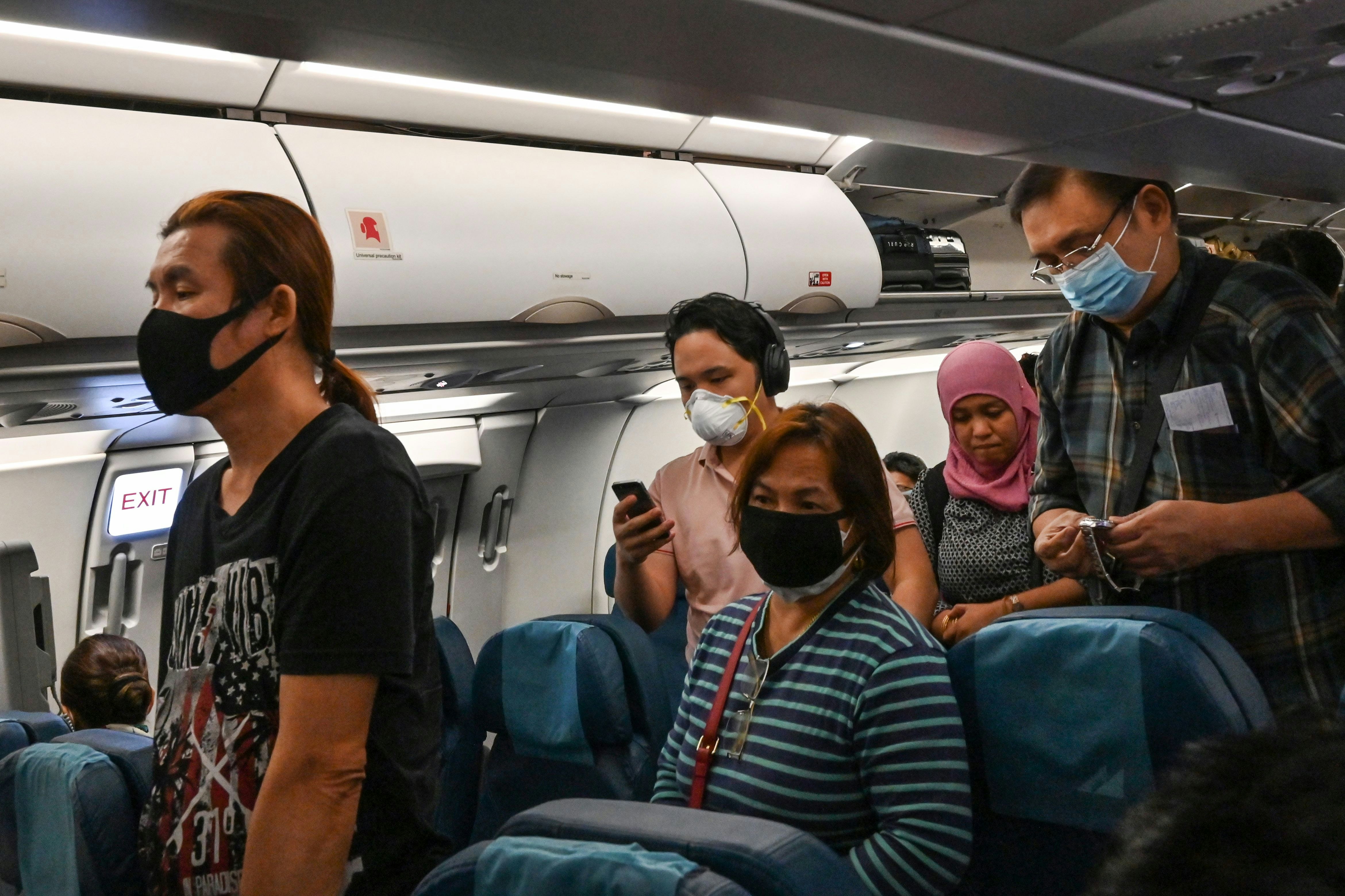 Passengers on a plane wearing facemasks