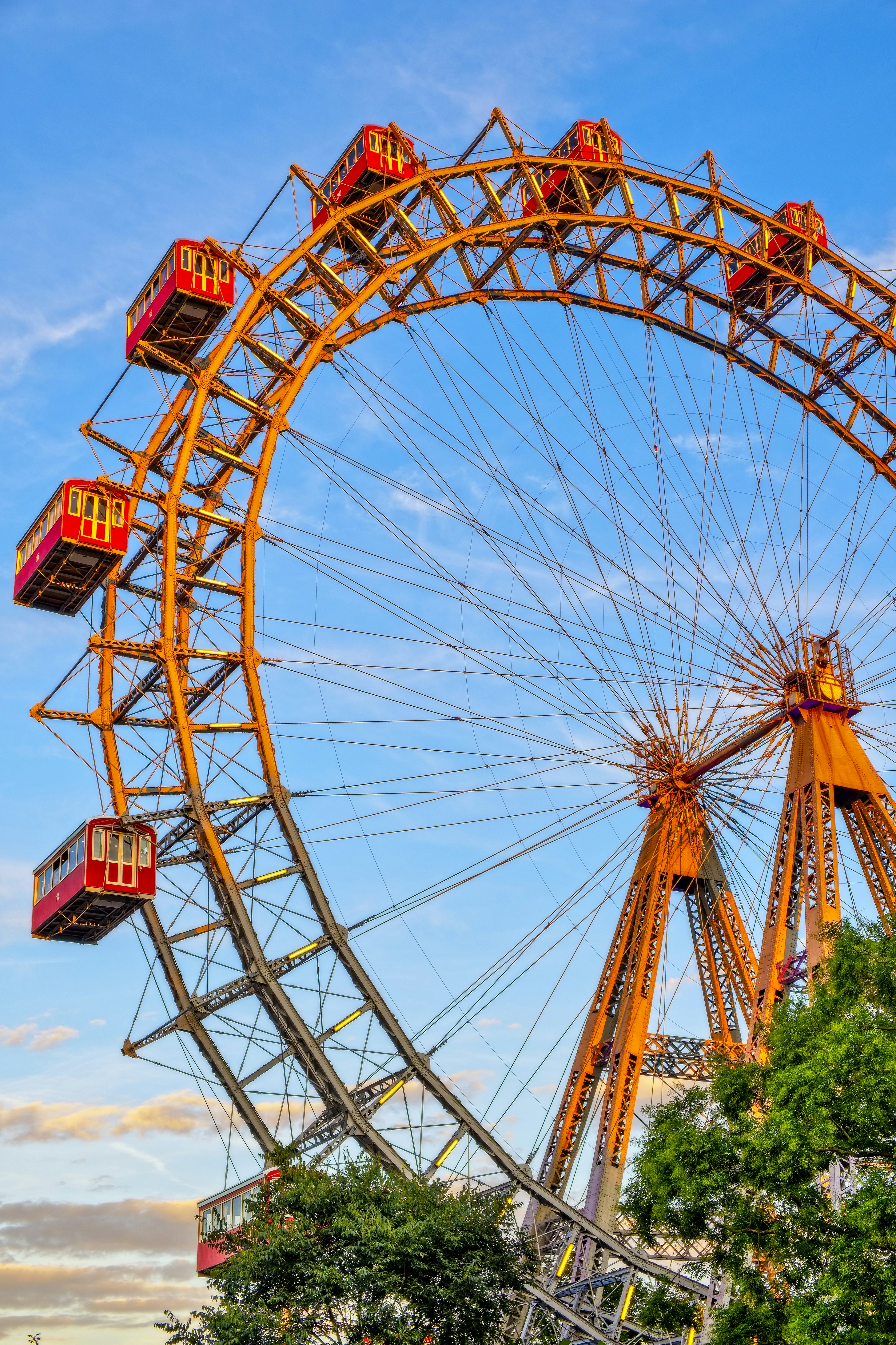 The huge Ferris Wheel in Prater Park in Vienna; attached to the yellow wheel are several enclosed red cabins.