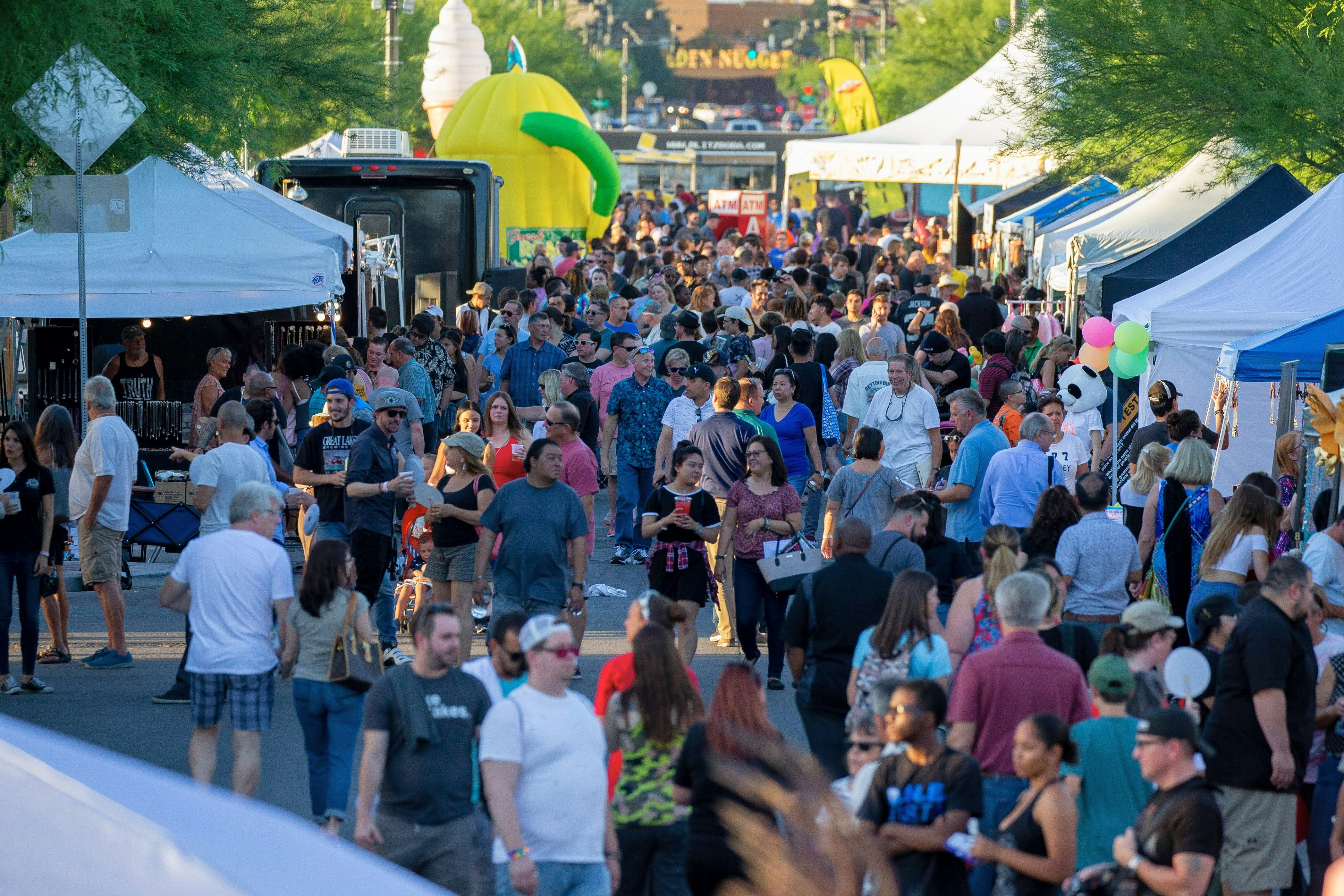 A large crowd fills a pedestrianized area lined with stalls at Las Vegas' First Friday Festival.
