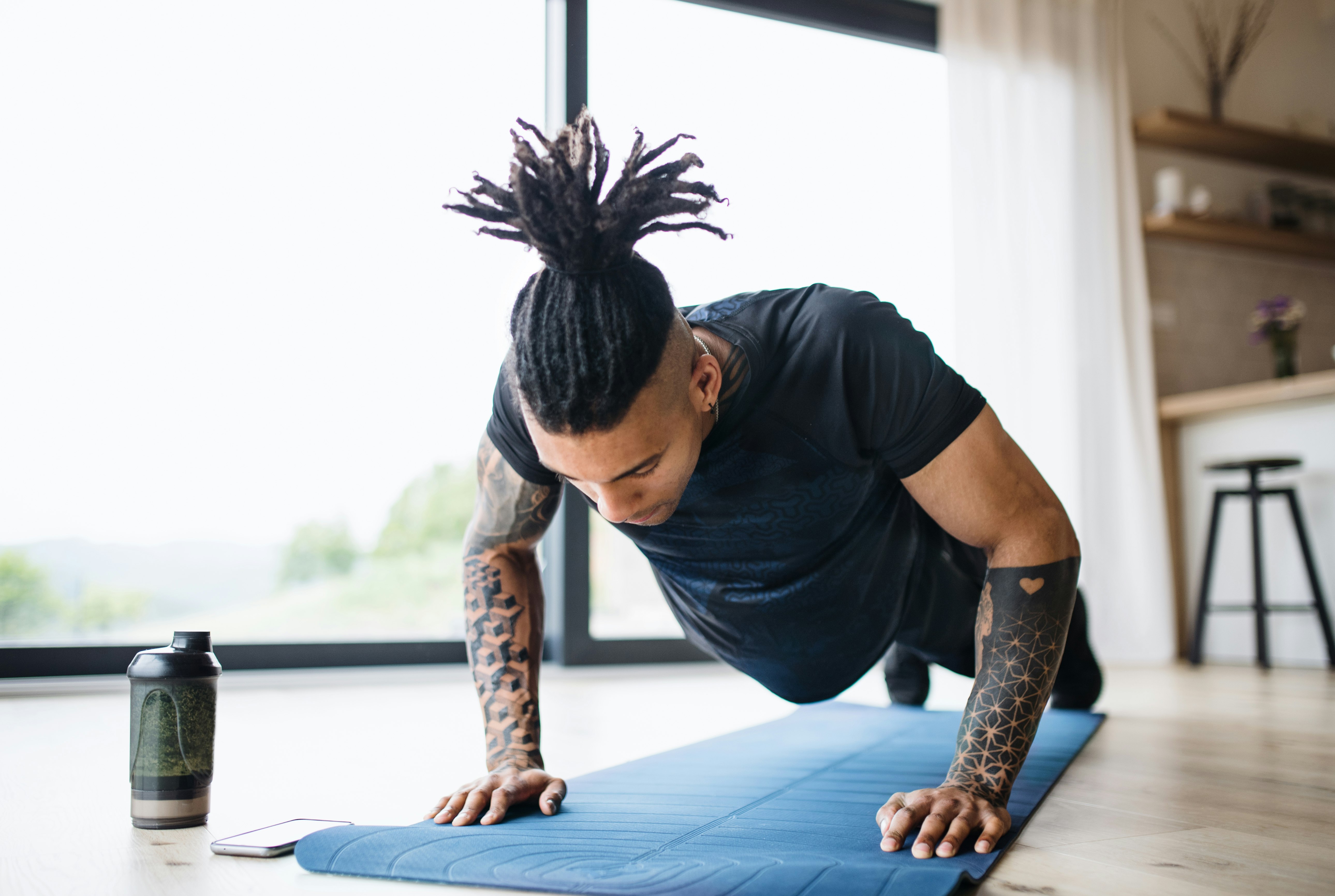 A man with dreads in a yoga pose