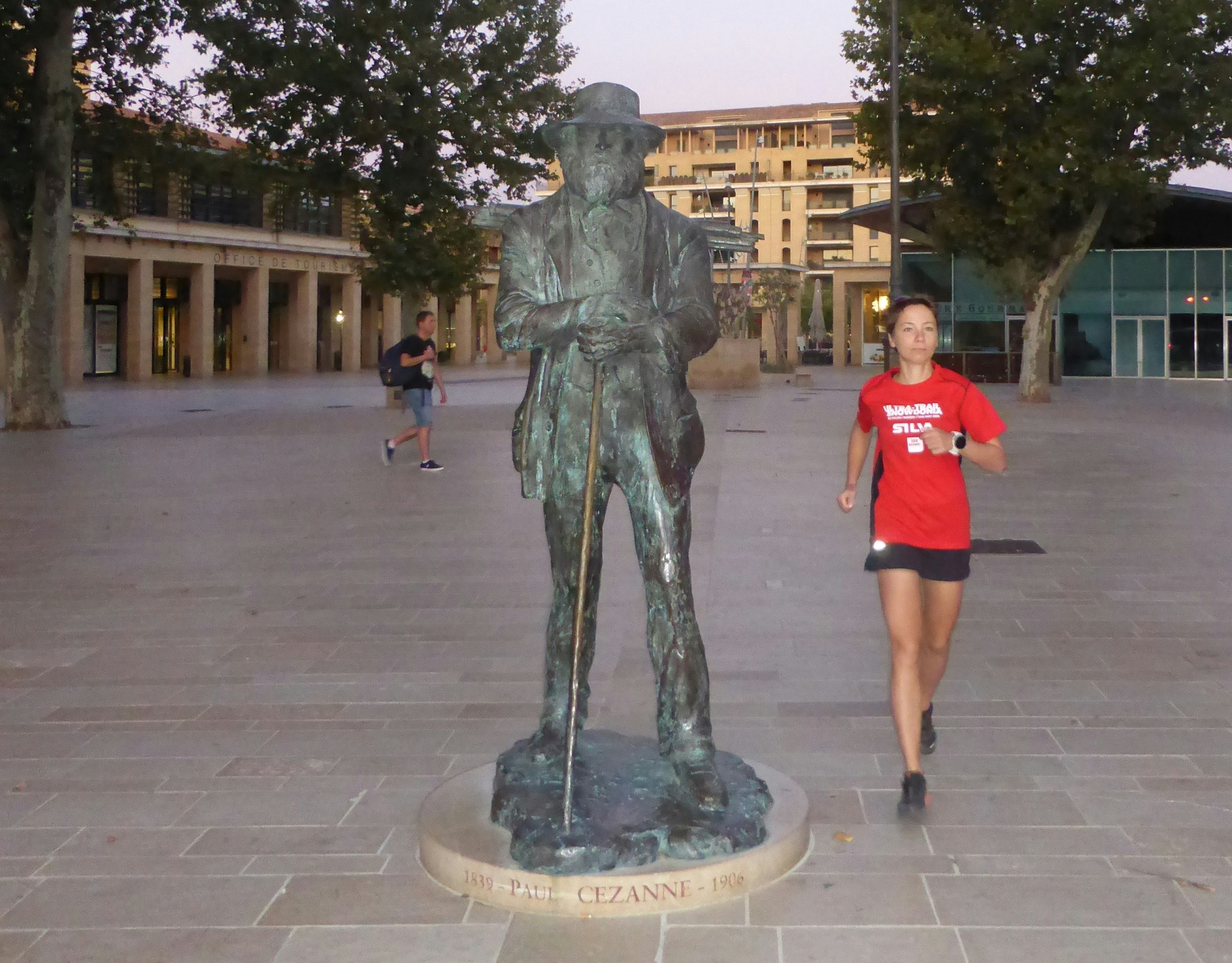 The writer runs towards the camera and past the Paul Cézanne statue.