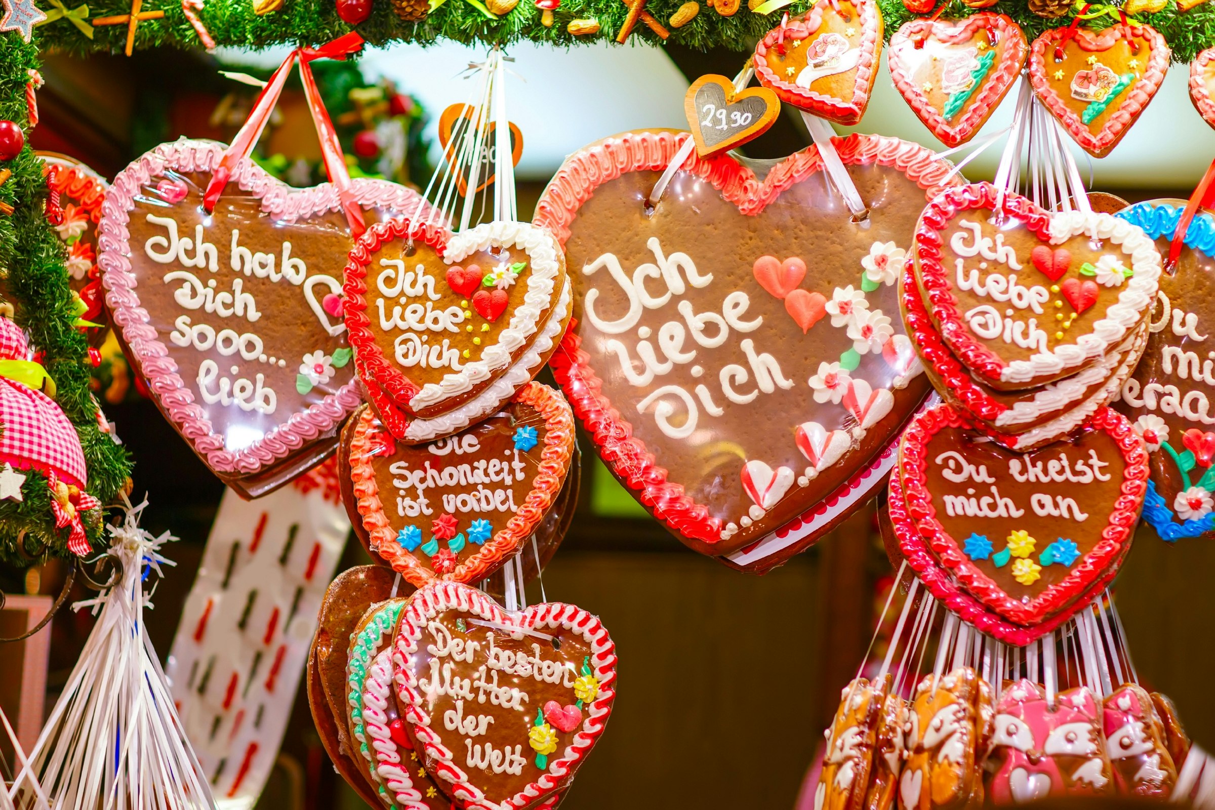 Hearts made of traditional gingerbread hang in the markets, with 'I love you' written in German.