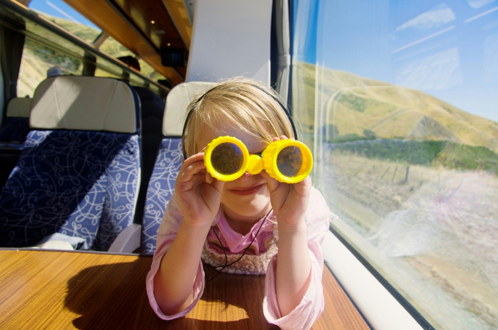 girl with binoculars looking out the window on train.jpg
