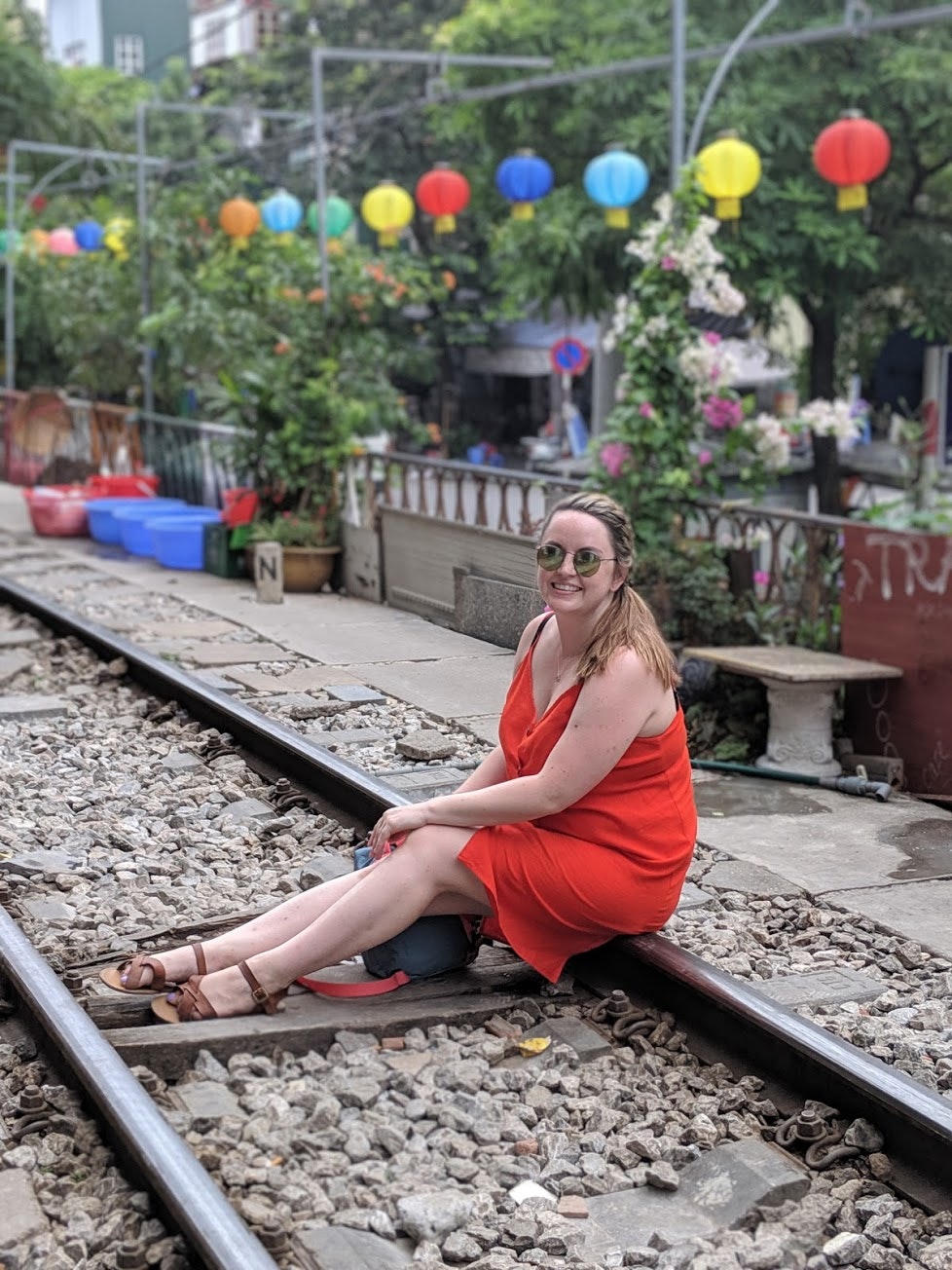 A young woman sits on disused train tracks in Hanoi