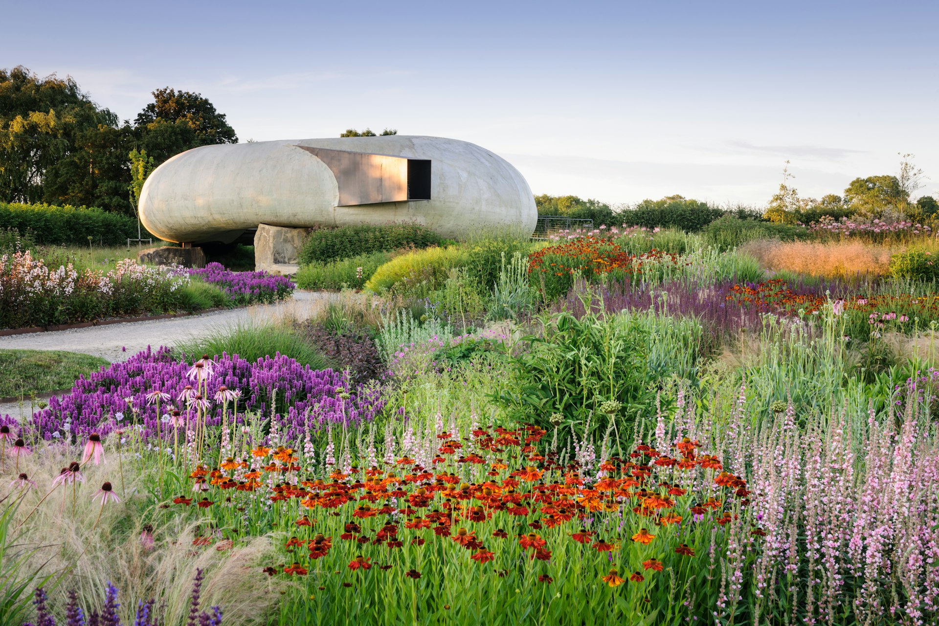 The concrete, conch-shaped Radić Pavilion at Hauser & Wirth Somerset sits amidst a colourful garden of wildflowers.