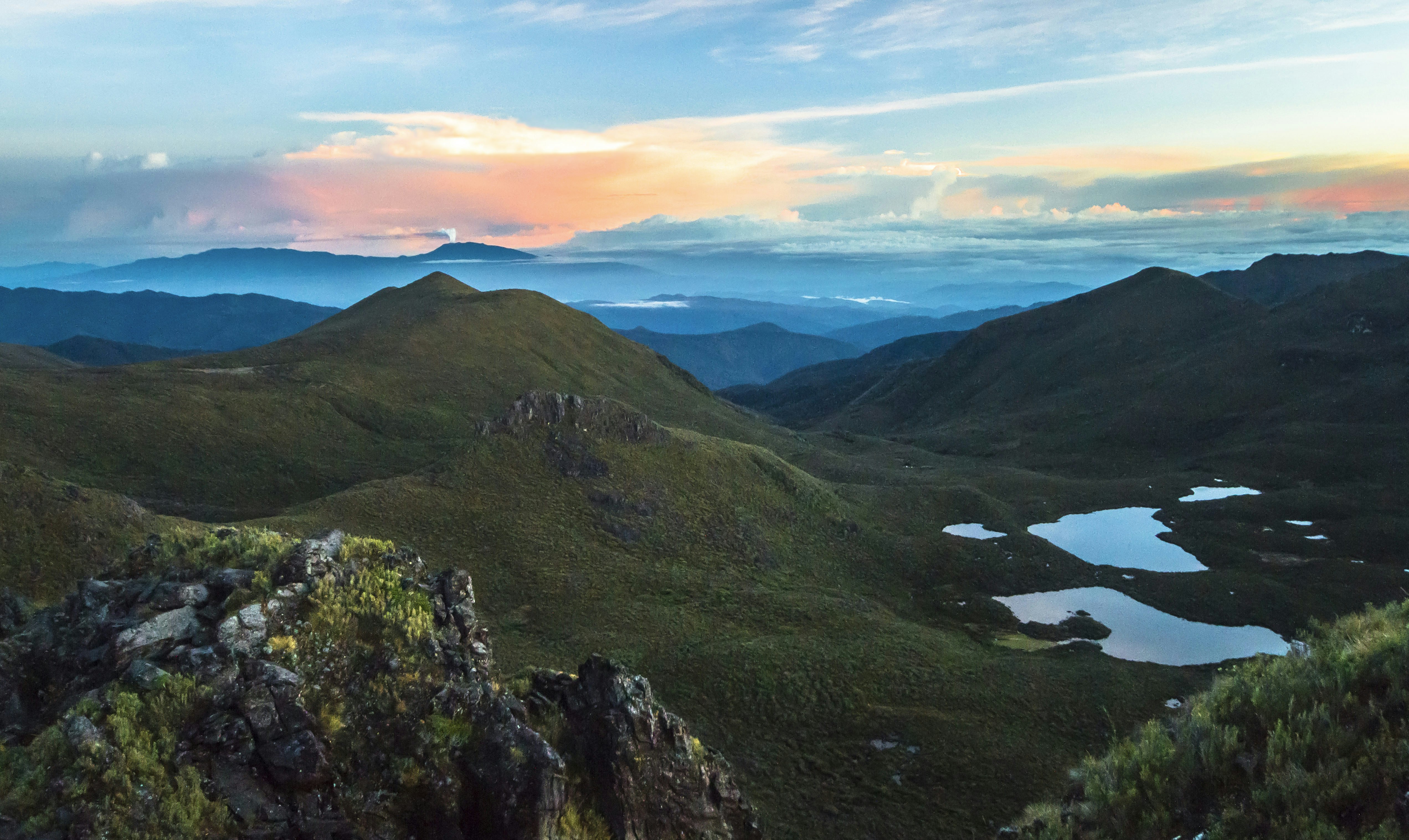 Volcan Turrialba erupts in the distance as the sun rises over mountain ranges, as seen from the summit of Cerro Chirripó, the highest point in Costa Rica.