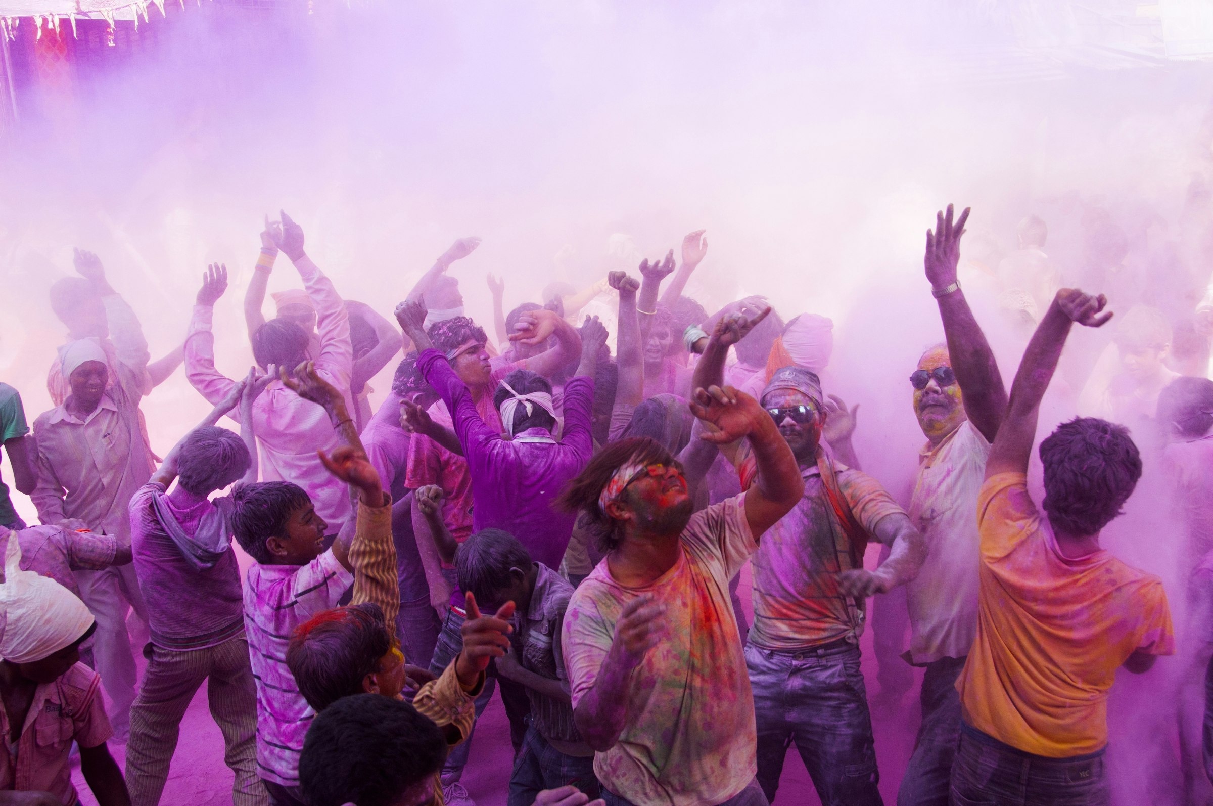  Crowd of men dancing while covered in purple powede