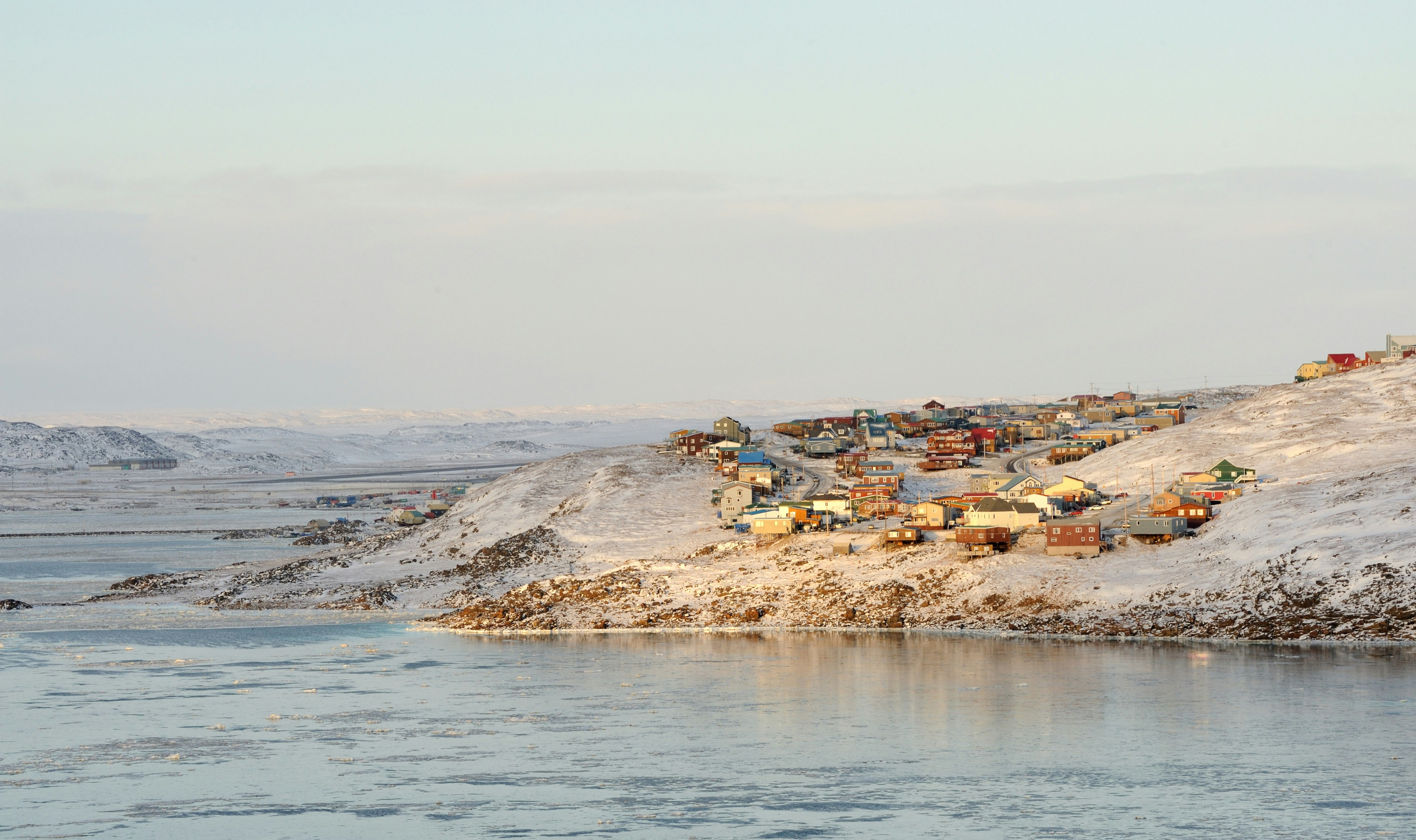 Colorful houses are arranged by the coast in snow-covered Iqaluit, Nunavut.