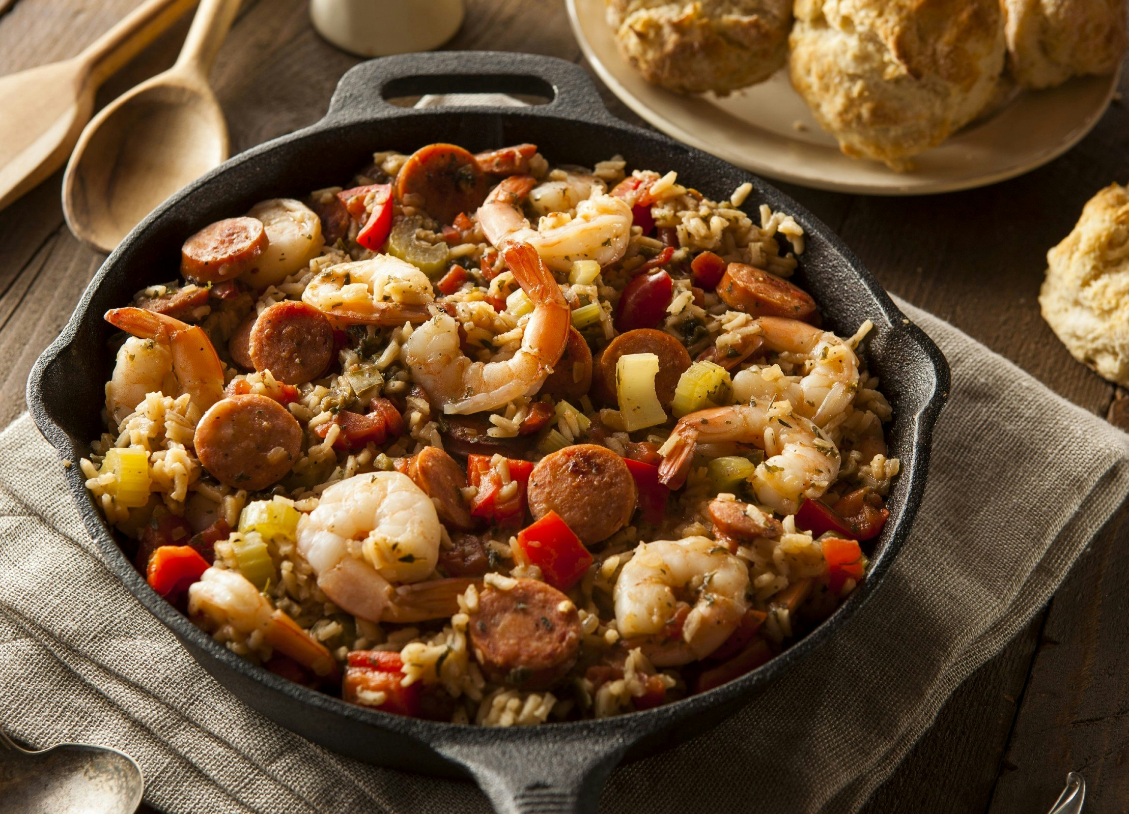 A top-down view of a pot of jambalaya, a rice dish containing prawns, meat and veg.