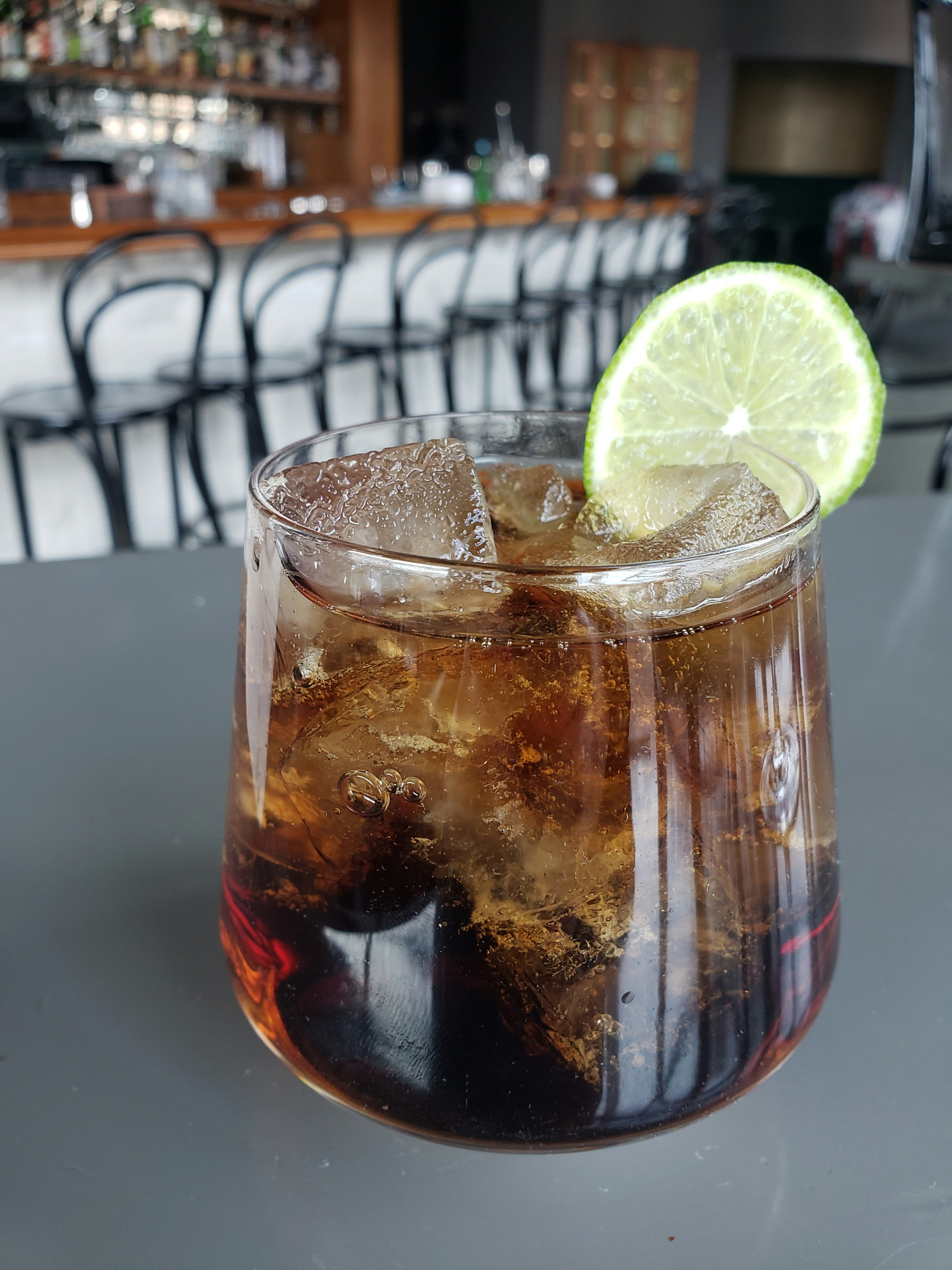 A glass tumbler filled with a dark brown, nonalcoholic cocktail at Julep in Kansas City.