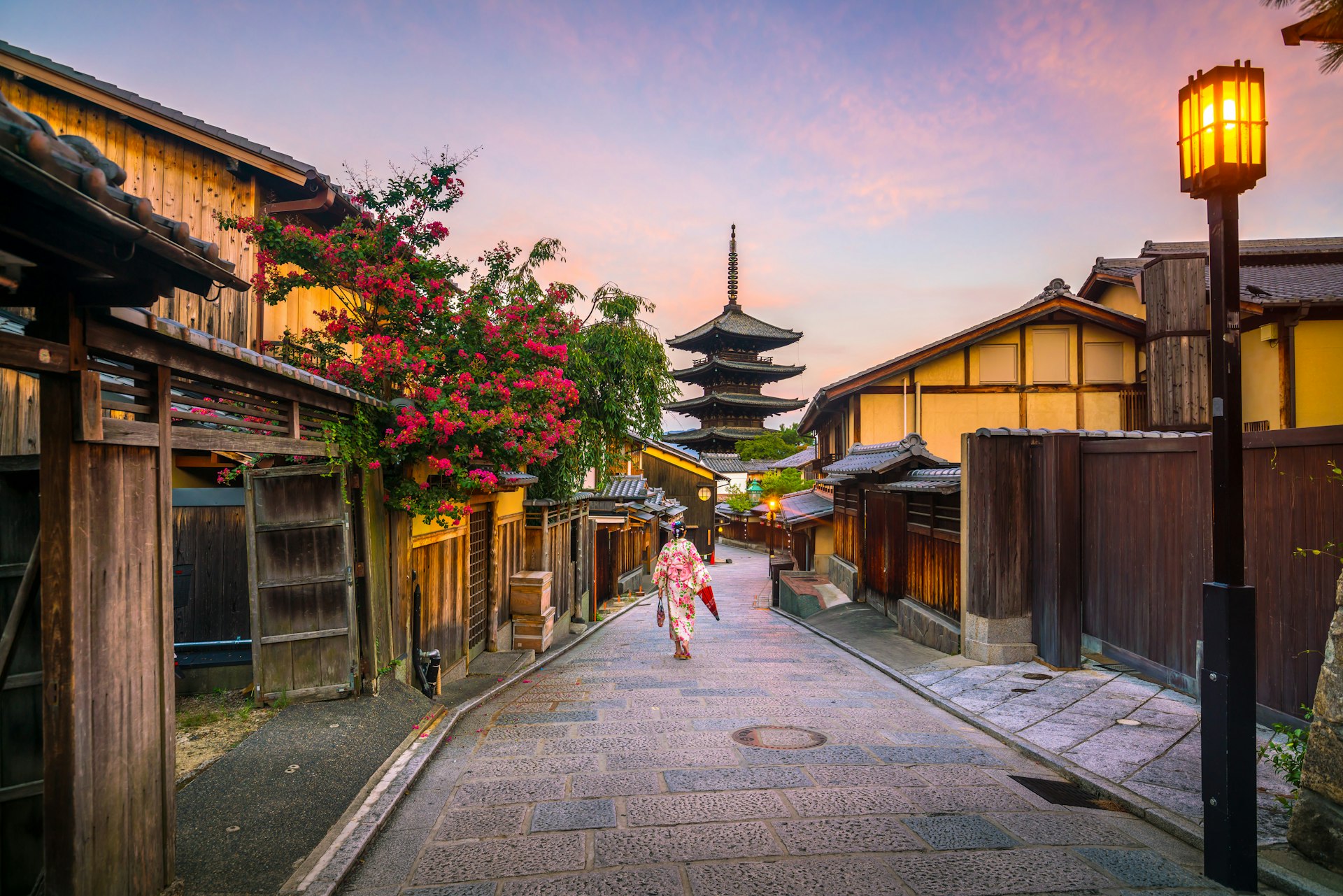 Japanese woman wearing a floral kimono walking through old town Kyoto, Japan