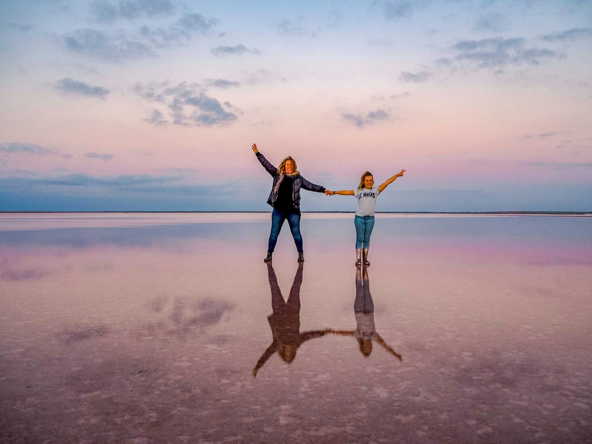 Evie Farrell and her daughter Emmie stand on the glassy salt flats at Lake Tyrrell, Australia.