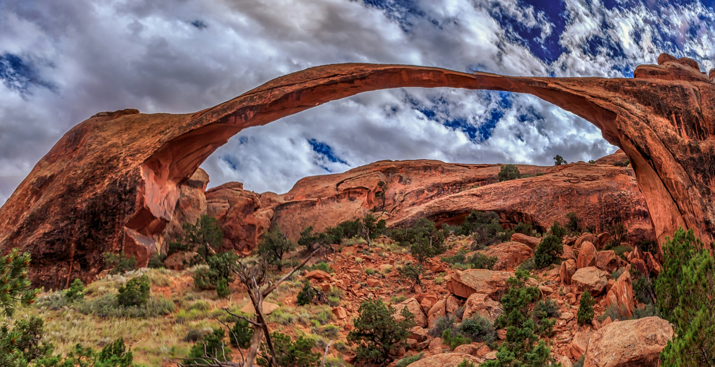 An HDR shot with vivid red and orange towns showing Landscape Arch in Utah's Arches National Park