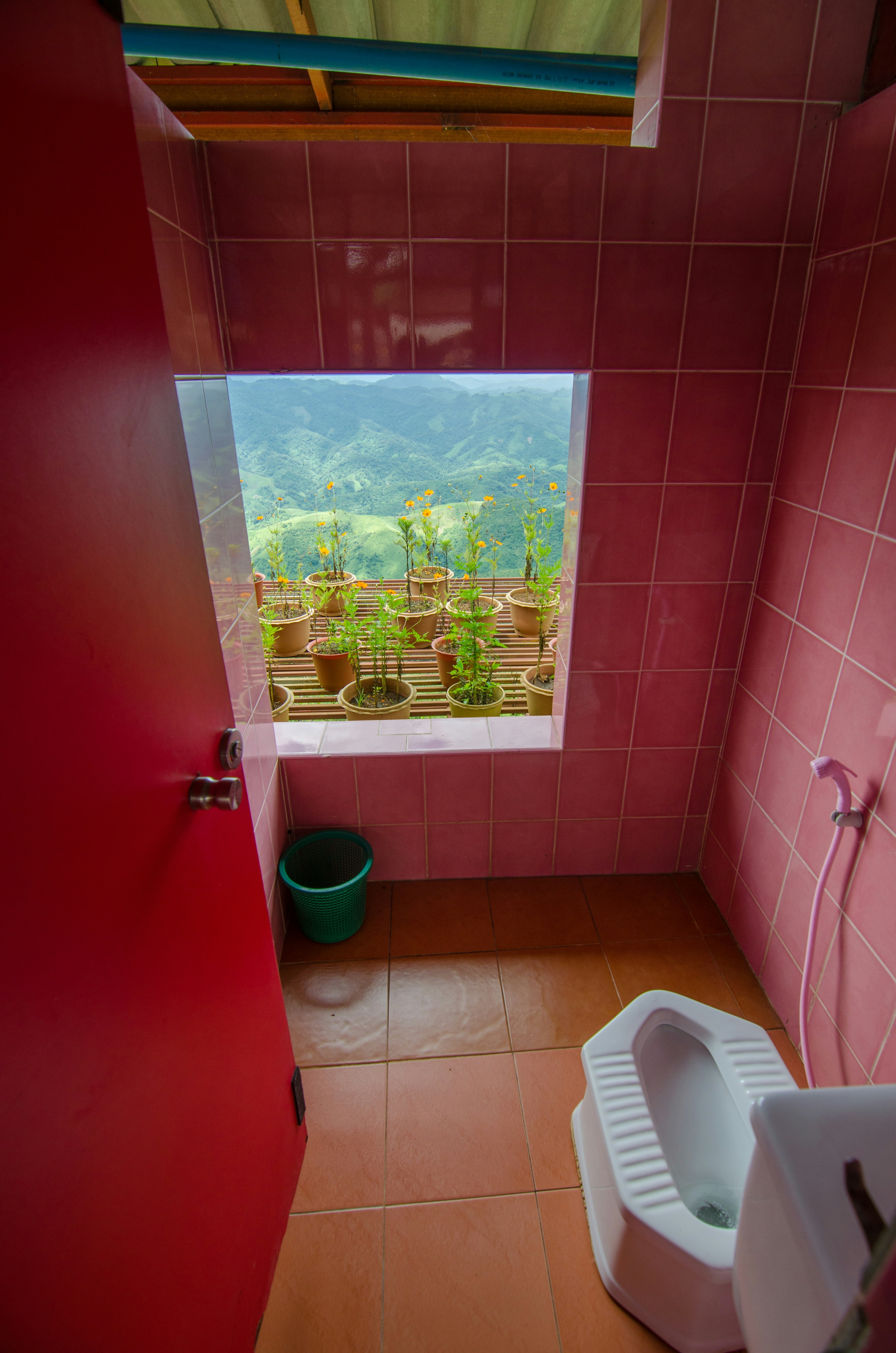 A toilet with a window overlooking a nice landscape