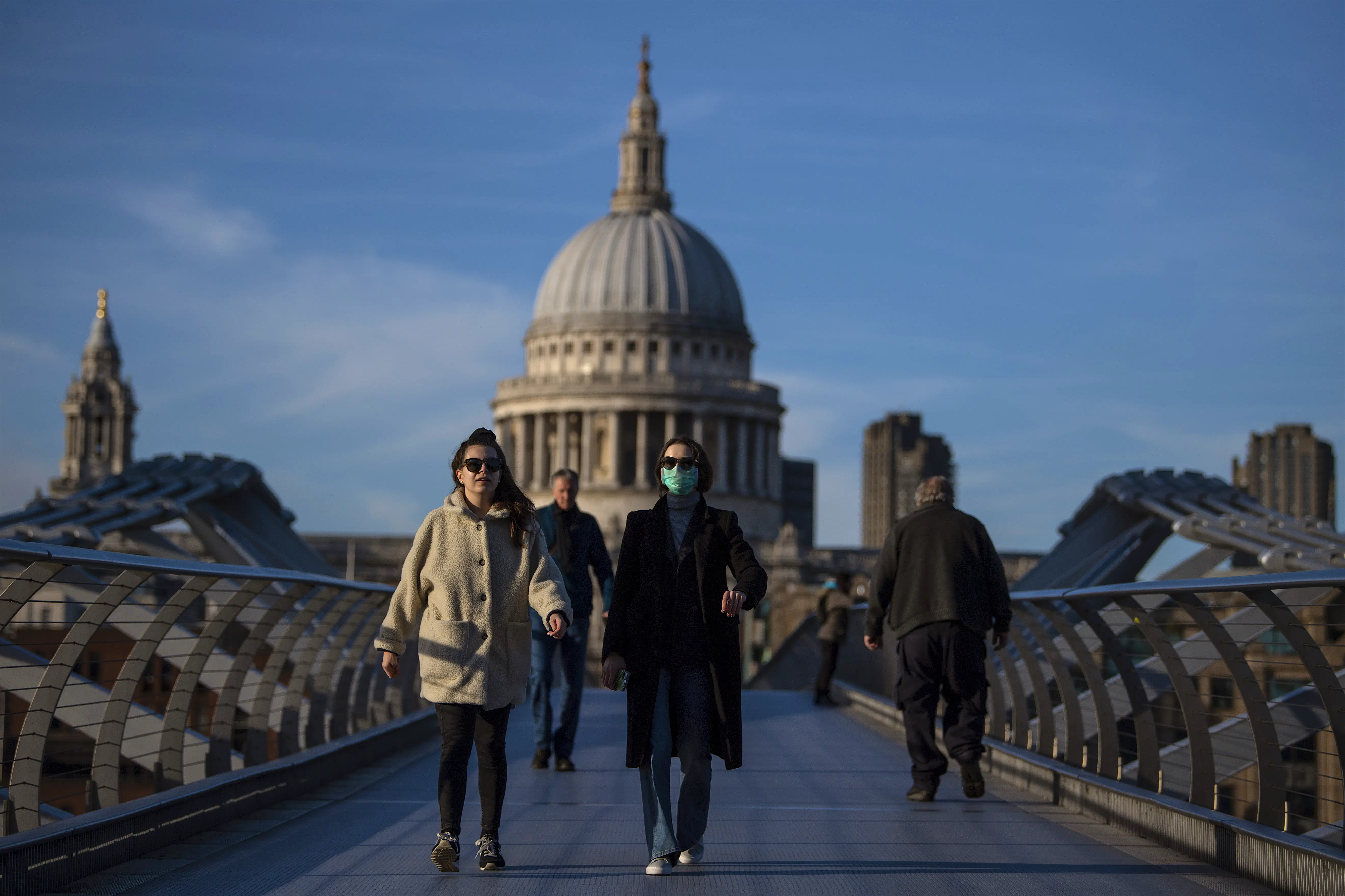 London during the COVID-19 pandemic A woman crosses the Millennium Bridge in front of St Paul's Cathedral wearing a face mask during the COVID-19 pandemic in London.