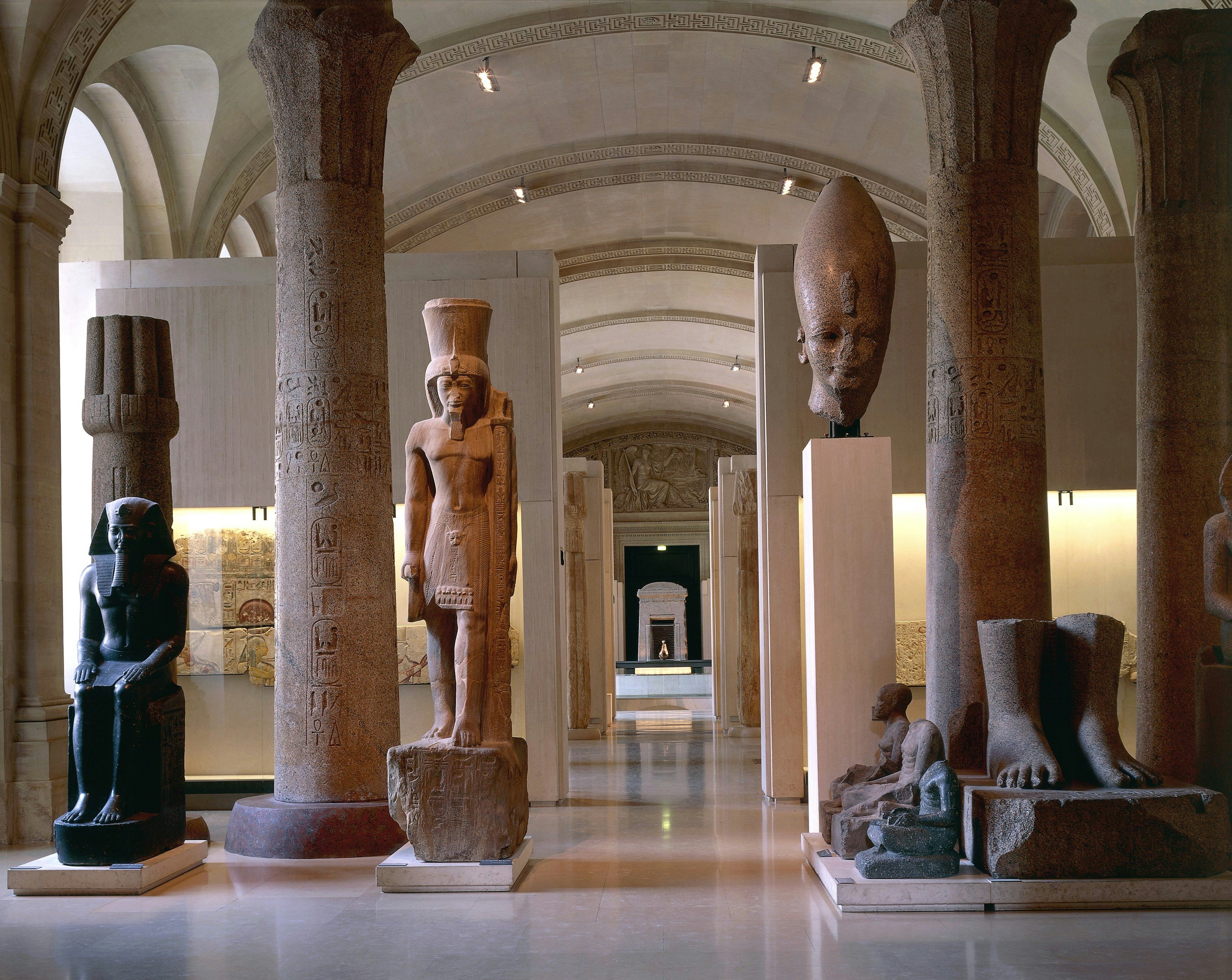 The Egyptian Antiquities room in the Lovure Museum is empty except for several statues of various sizes from Tanis, Karnak, and Thebes