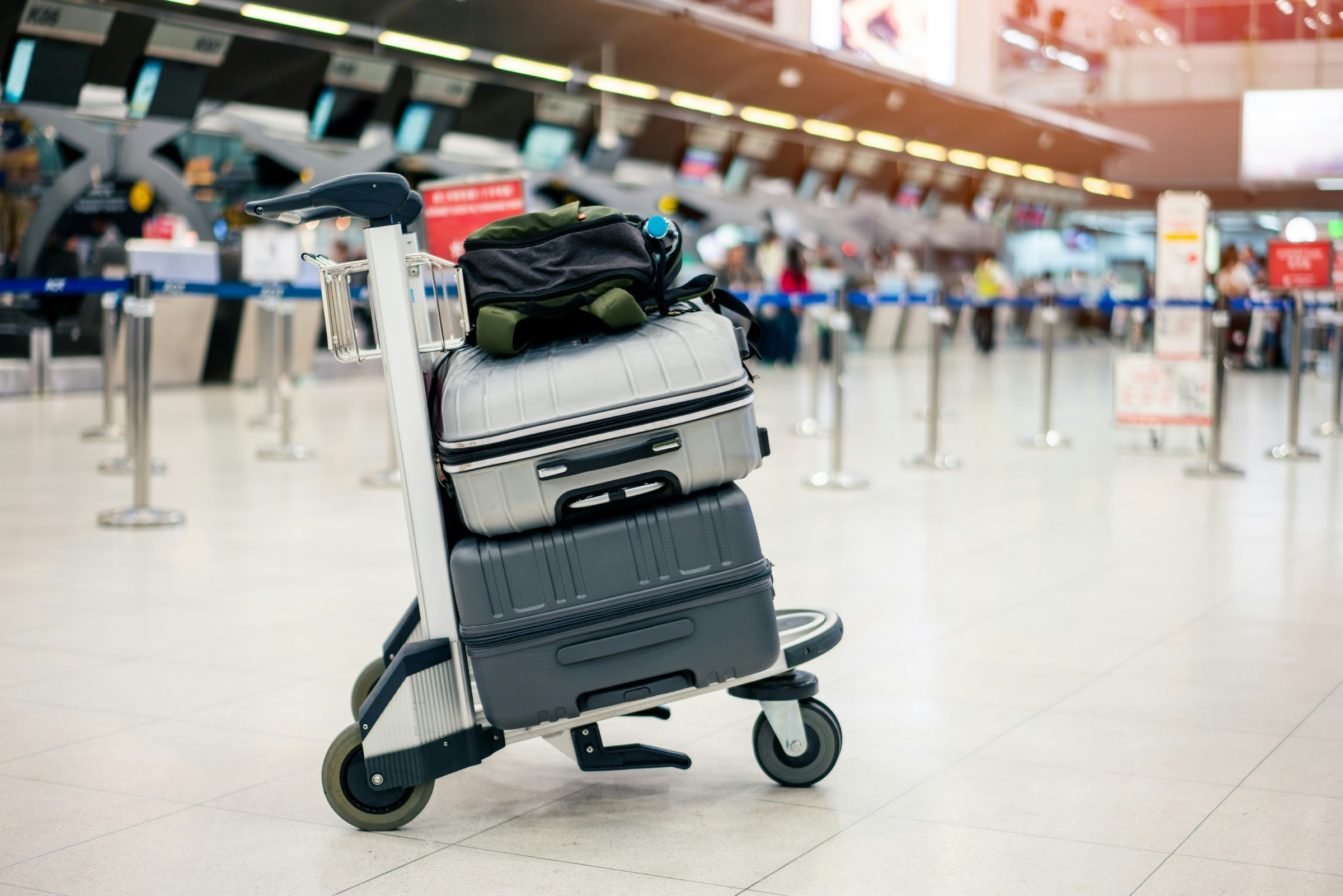 Suitcases stacked on a luggage trolley in an international airport