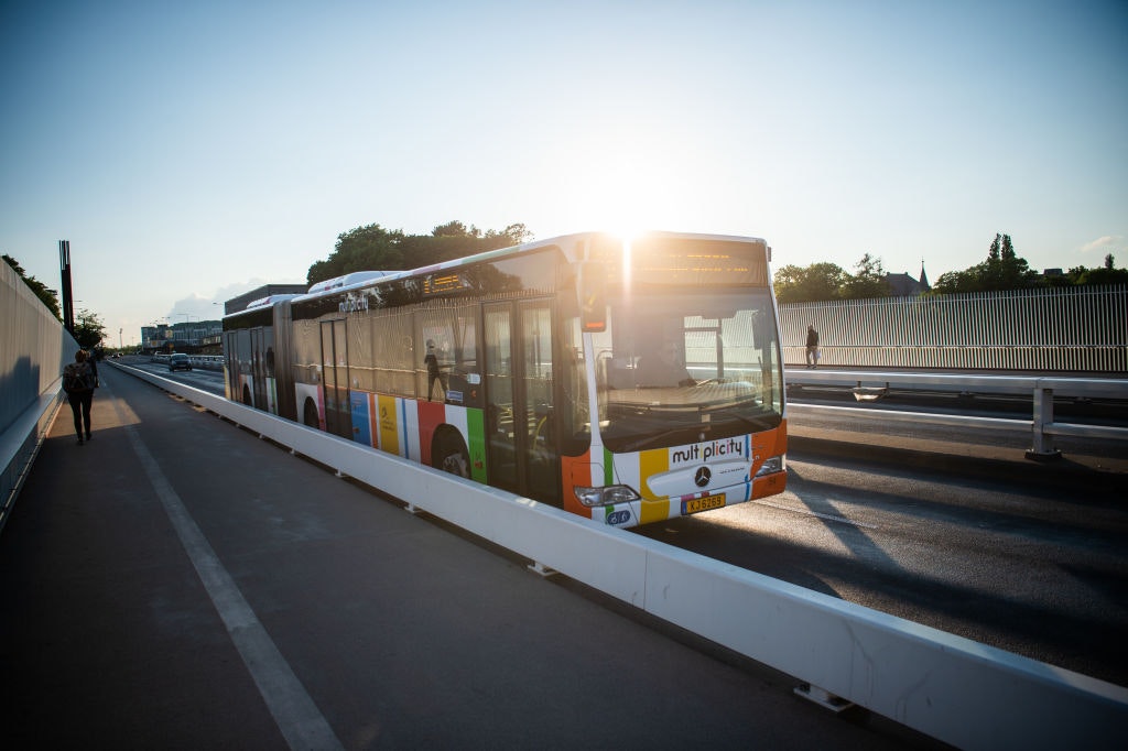 A public bus travels against the sunset on a Luxembourg bridge