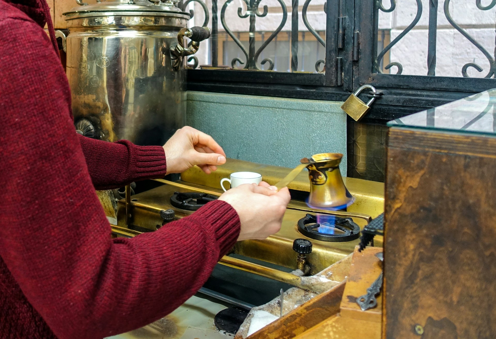 A man in a red sweater makes Turkish coffee