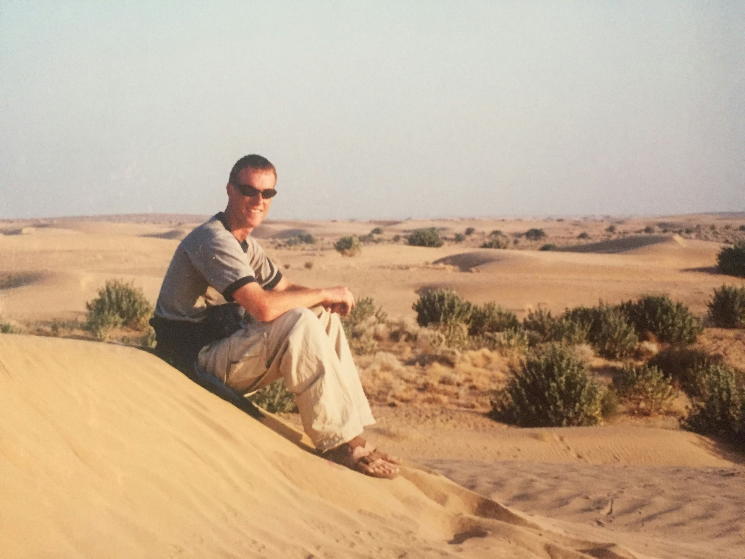 Writer sits on a sand dune in the desert near Jaisalmer India