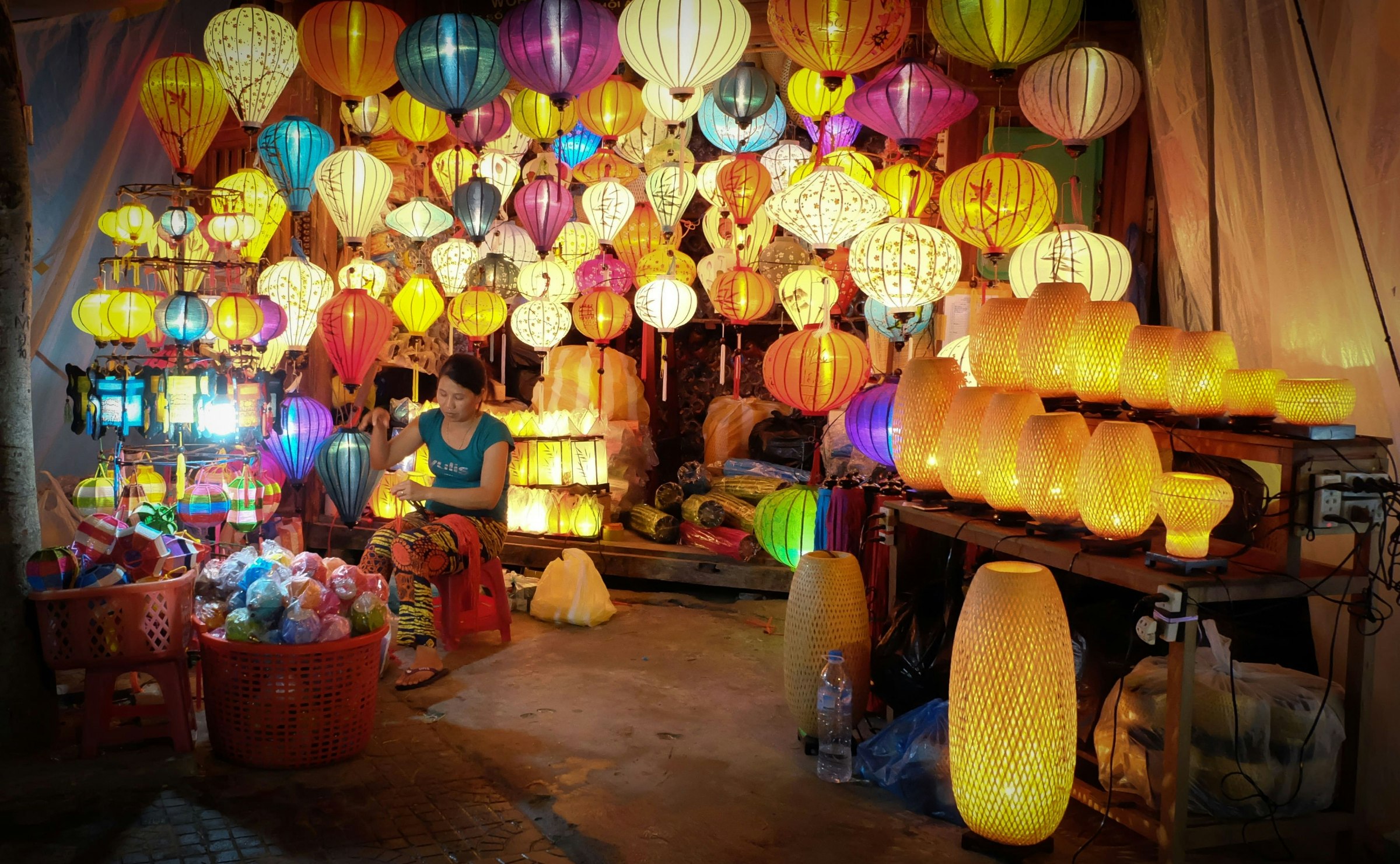 A young woman is selling colourful lanterns at a market in Hoi An