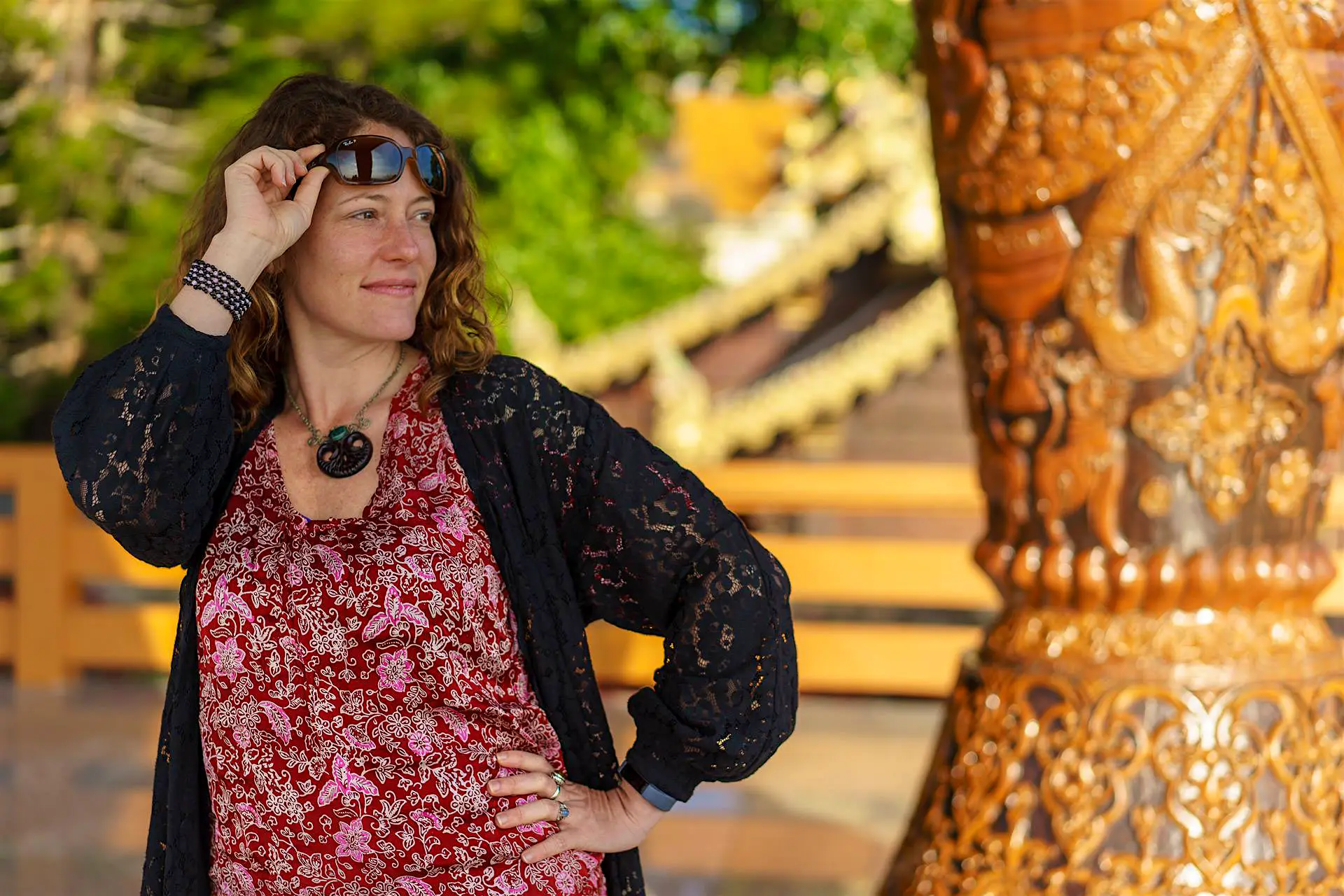 nora dunne budget solo travel.jpg The author poses in Thailand, hand on hip, lifting sunglasses off her head