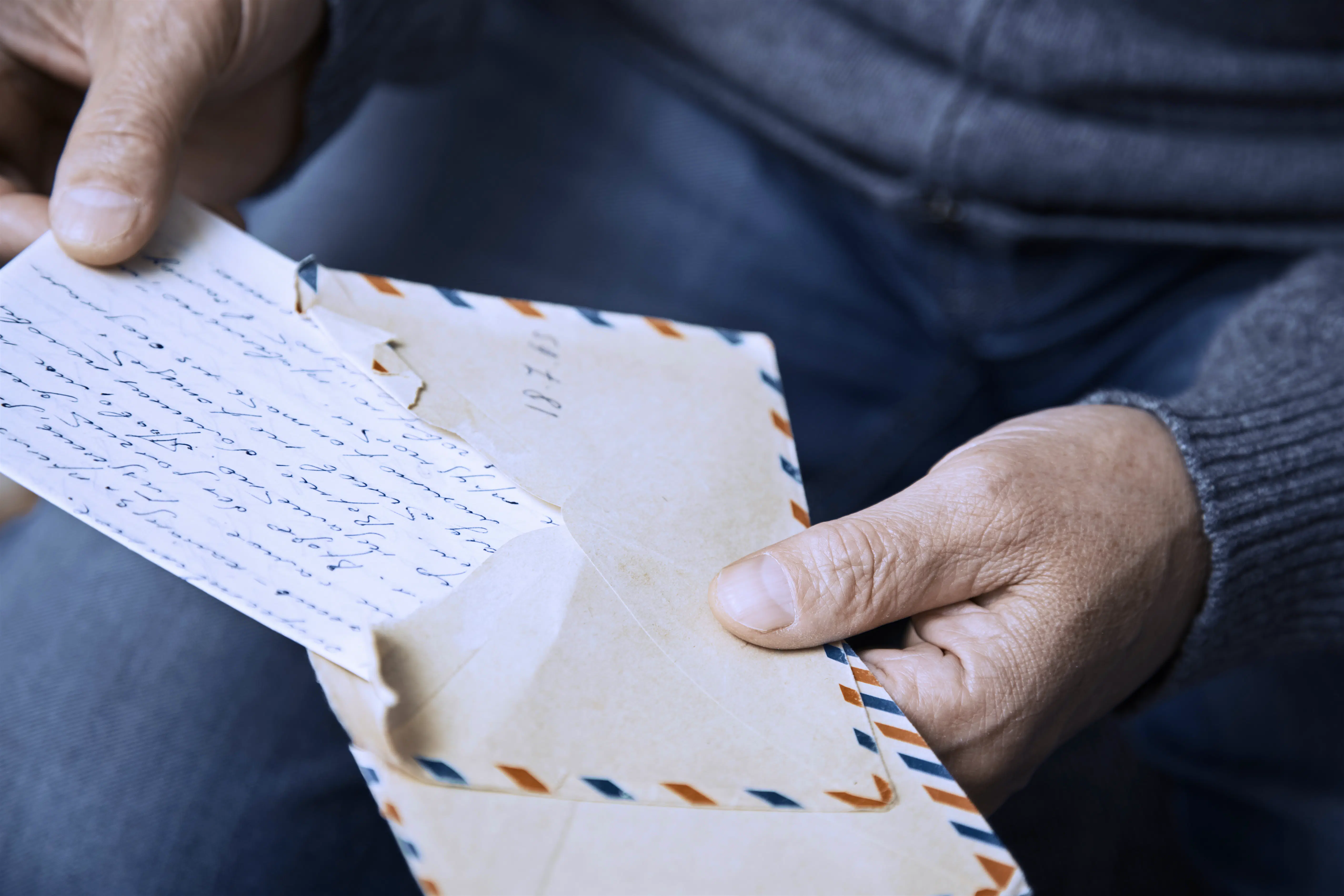 old man opening a letter.jpg The hands of an elderly man open an envelope and handwritten letter