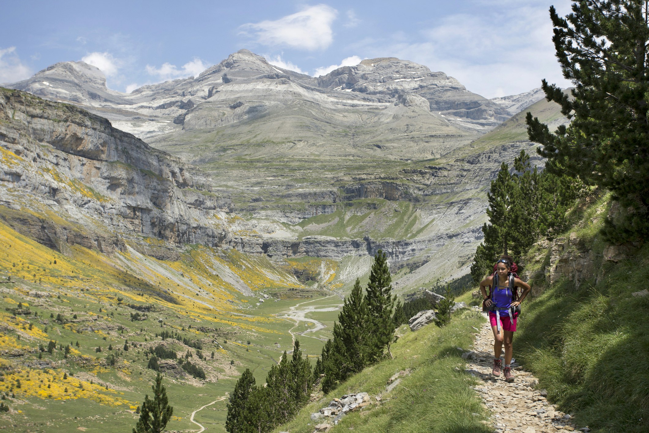 A woman hikes on a trail in the Pyrenees mountains, Spain