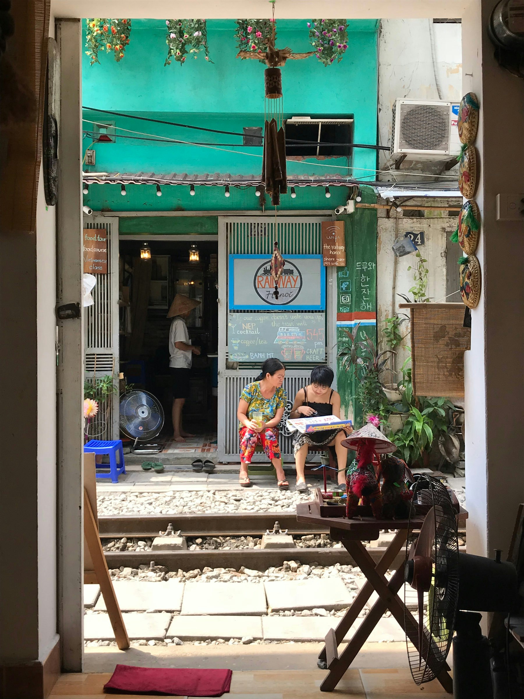 Two women sit outside the cafe in the sun