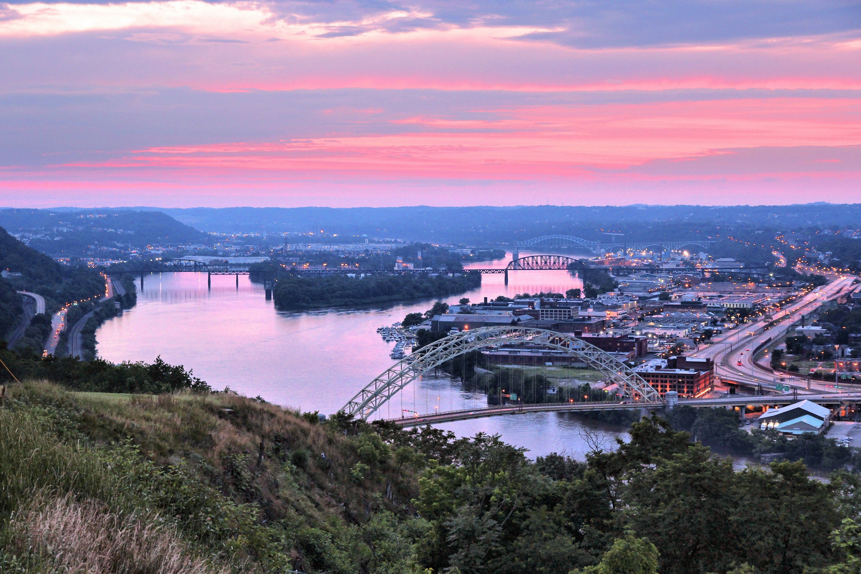 A view of Pittsburgh looking north over the West End Bridge towards Brunot Island and the Chateau District at sunset, which is drying the sky and the Ohio River  brilliant shades of pink and orange .jpg
