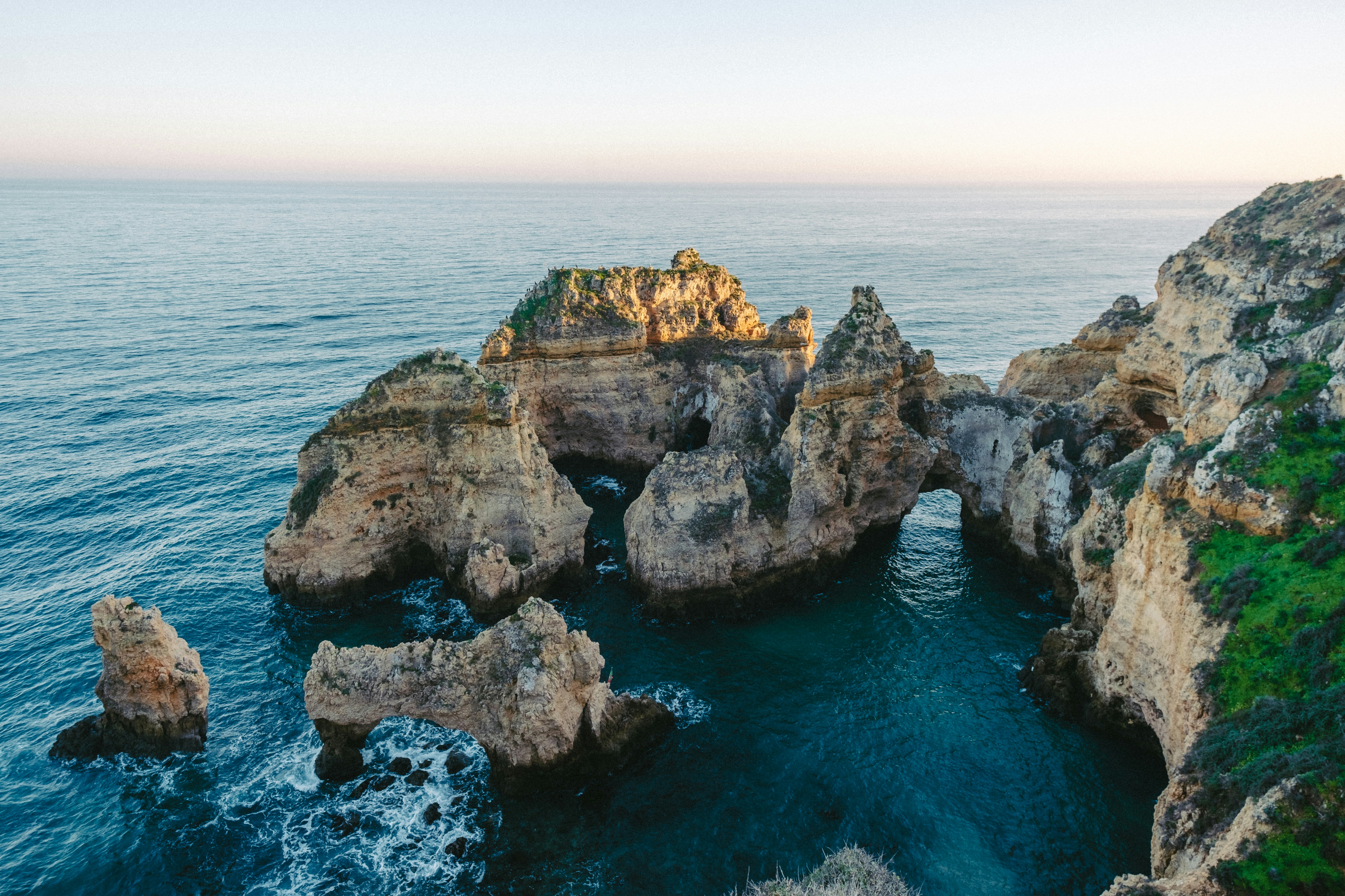 The weathered, eroded cliffs at Ponta da Piedade. Waves crash and froth around the rock stacks.