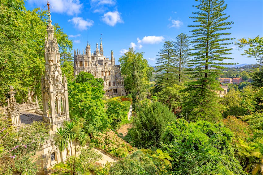The spires of Quinta da Regaleira are visible through the trees from an elevated viewpoint.