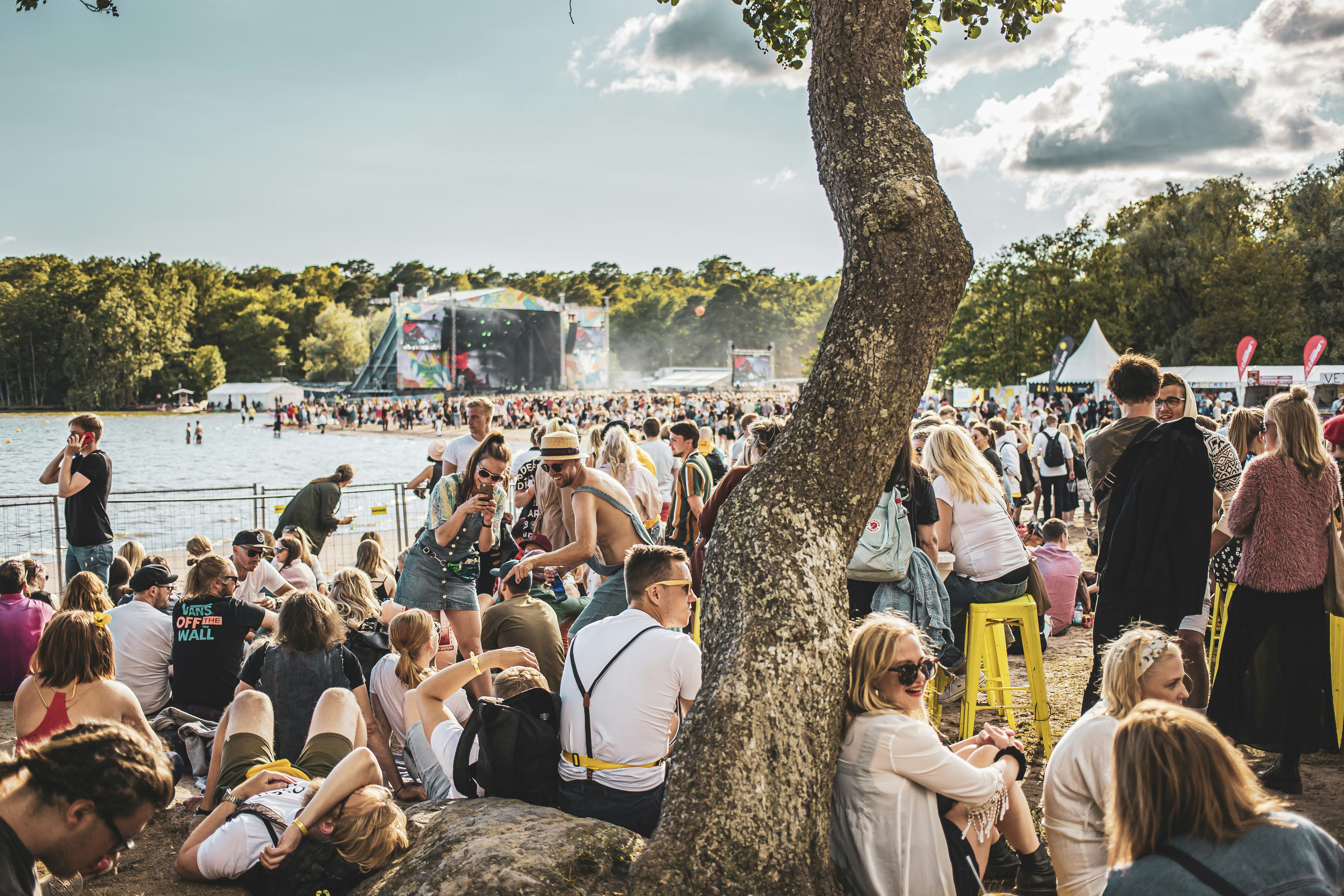 A large crowd of people lounge around in the sunshine at the Ruisrock festival on Ruissalo Island.