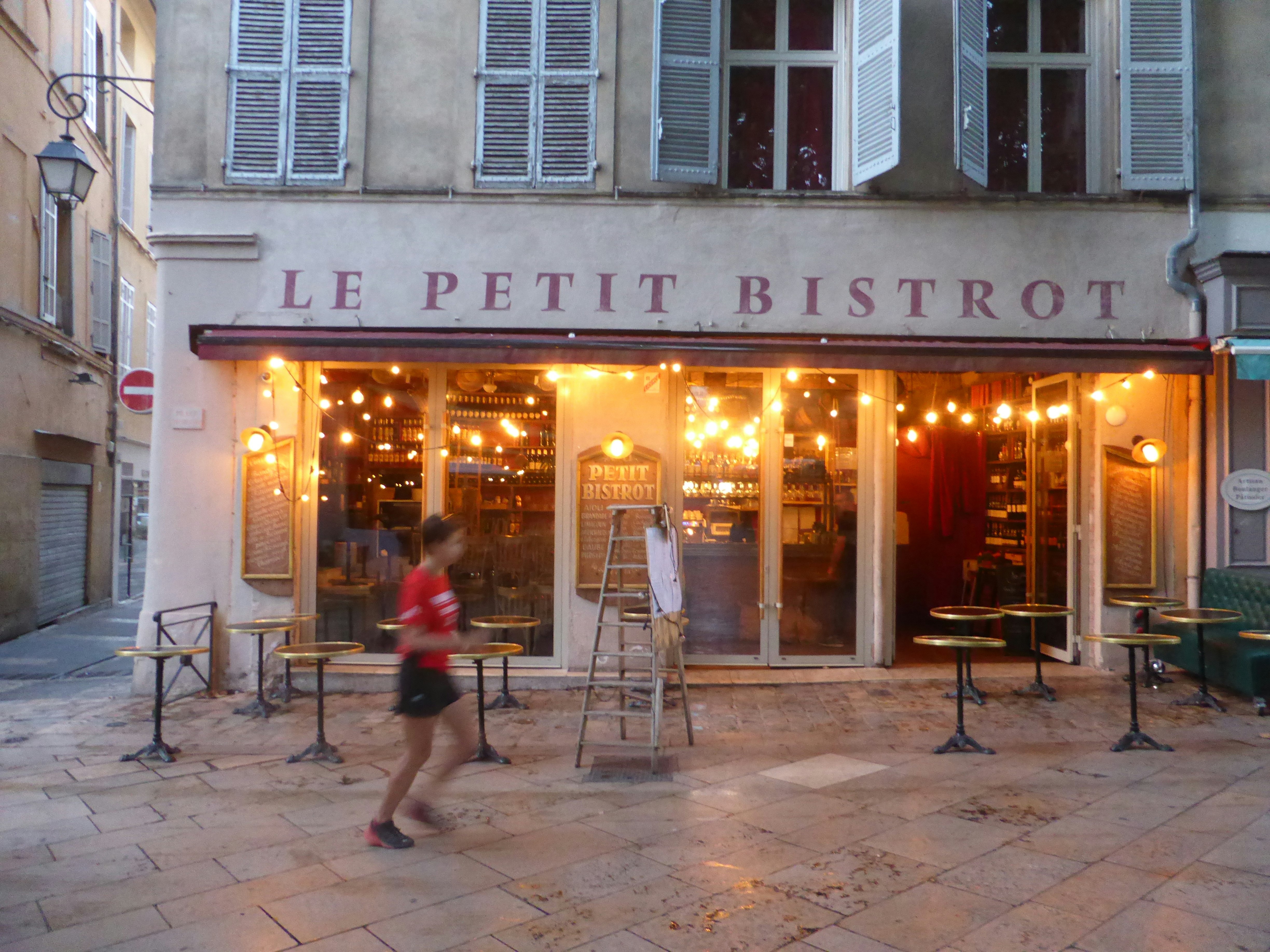 The writer is blurred as she runs past Le Petite Bistrot in Aix-en-Provence.