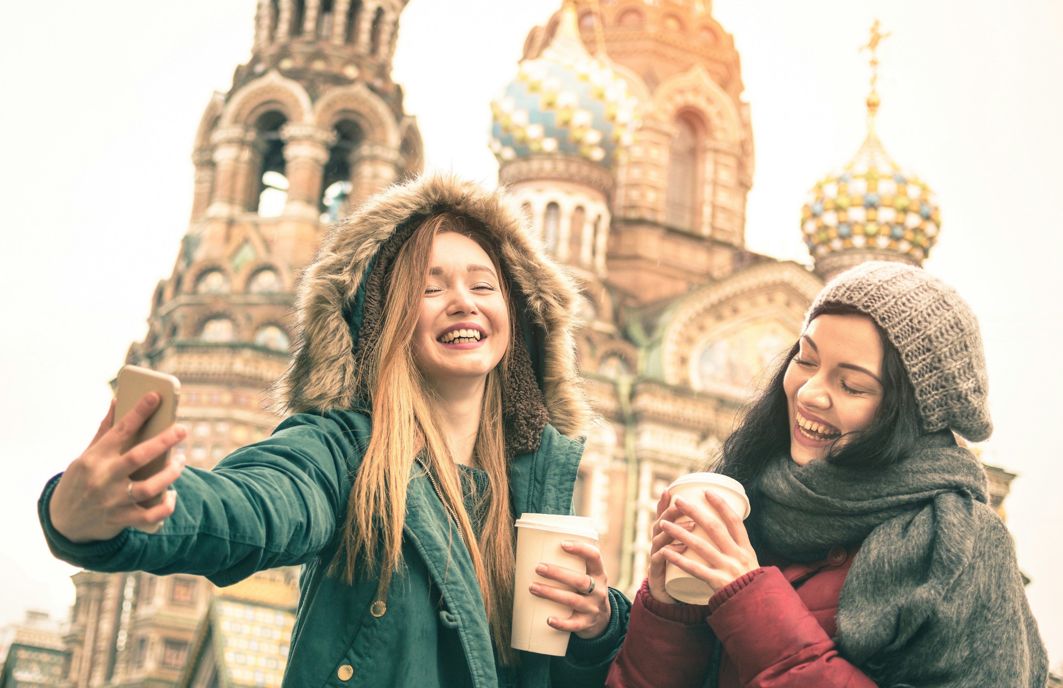Two laughing girls take a winter selfie outside the Savior on Spilled Blood church in Saint Petersburg, Russia.