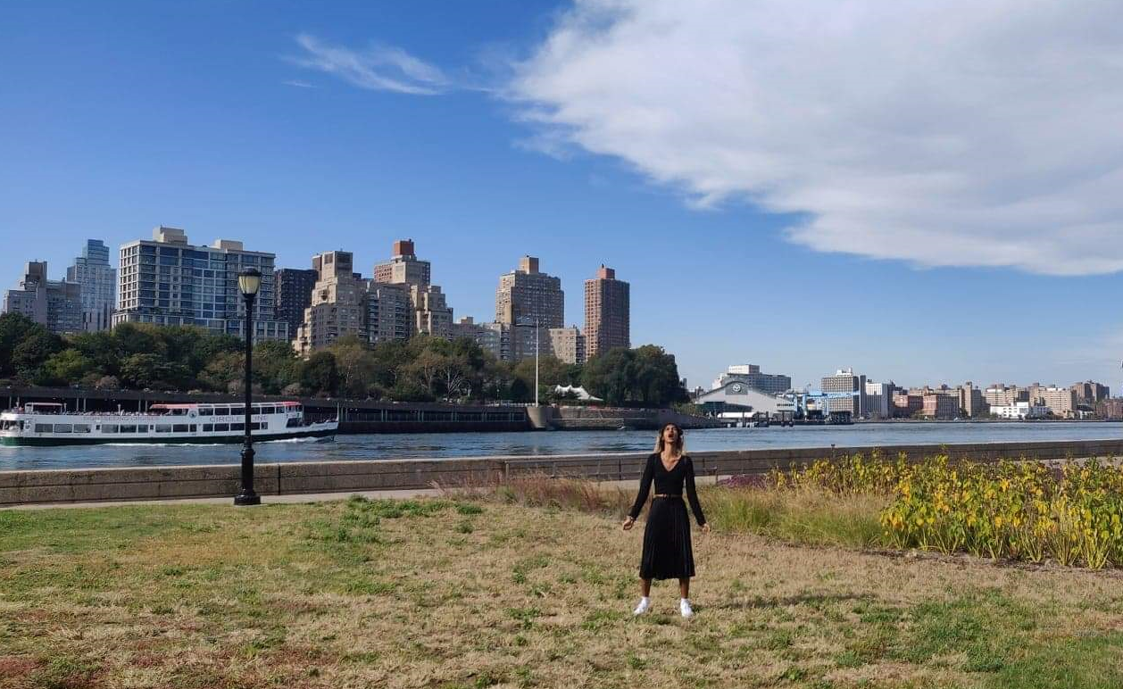 Young woman in coat screams by a Manhattan harbour