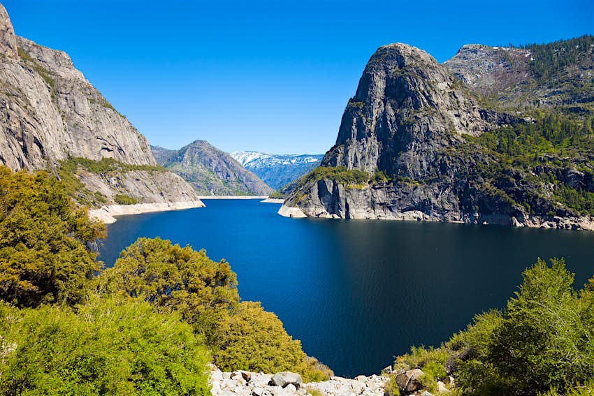 Hetch Hetchy Reservoir with blue sky above in Yosemite National Park.