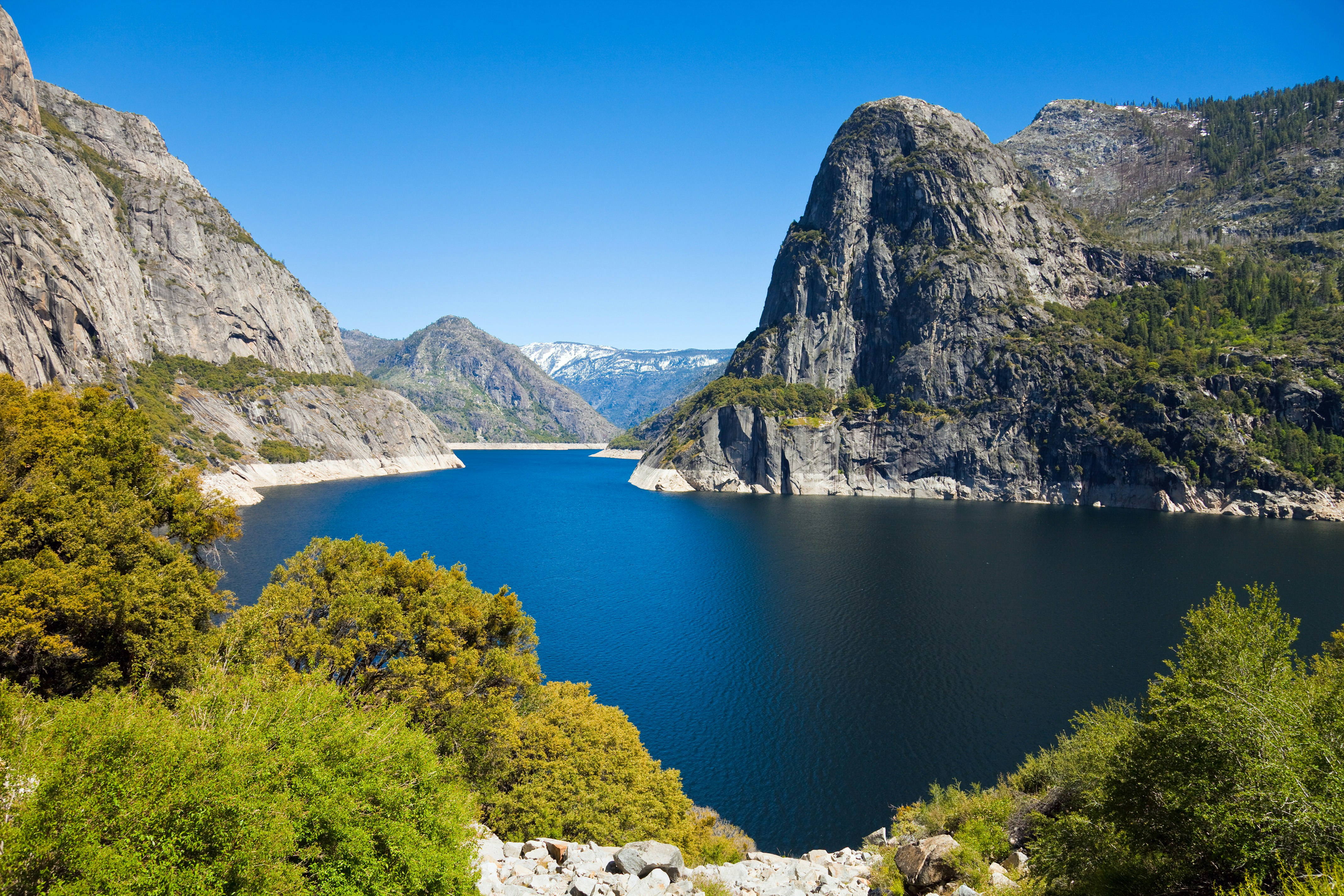 Hetch Hetchy Reservoir with blue sky above in Yosemite National Park.