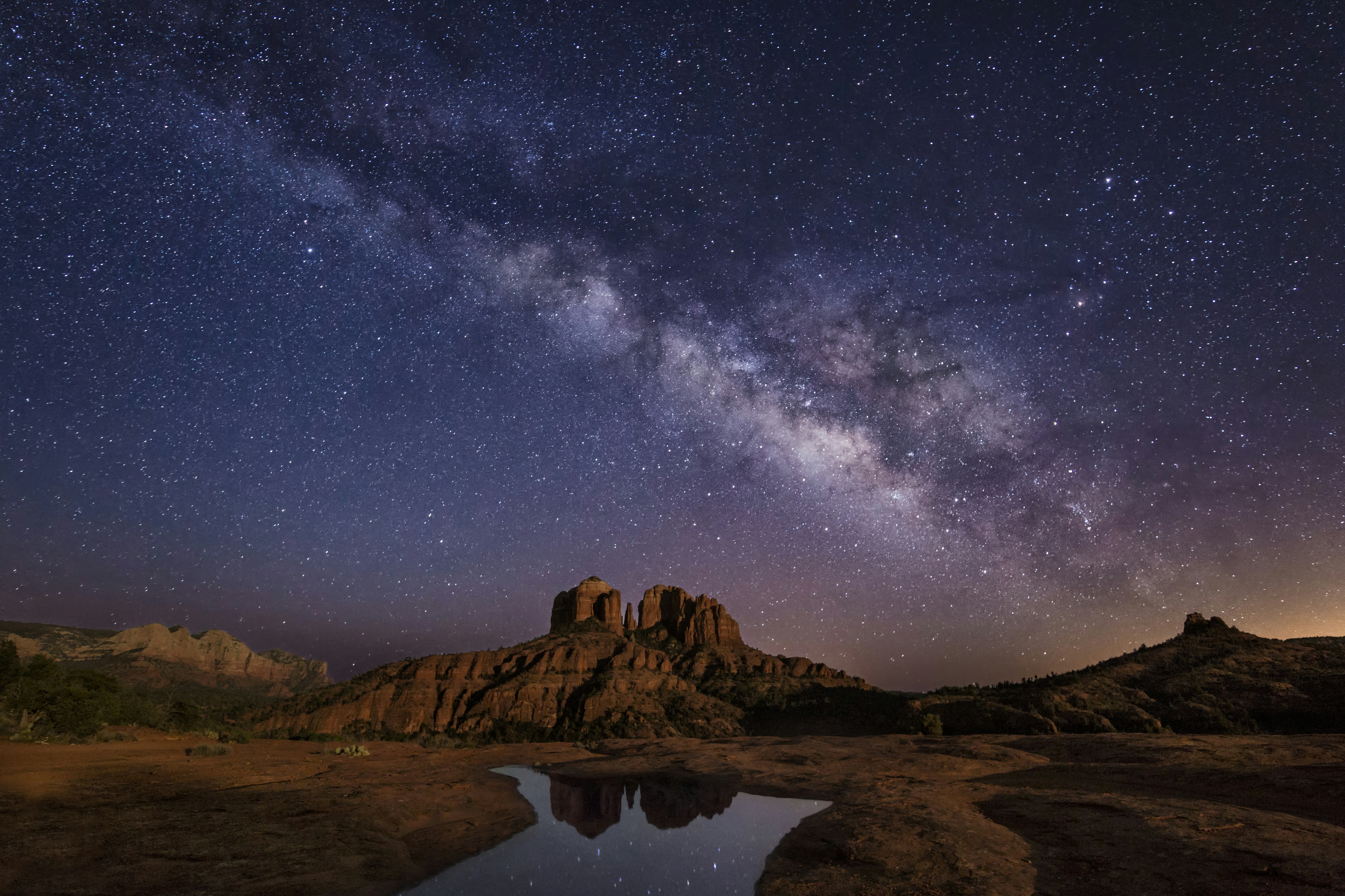 The Milky Way shines over a dramatic desert landform at Cathedral Rocks near Sedona, Arizona