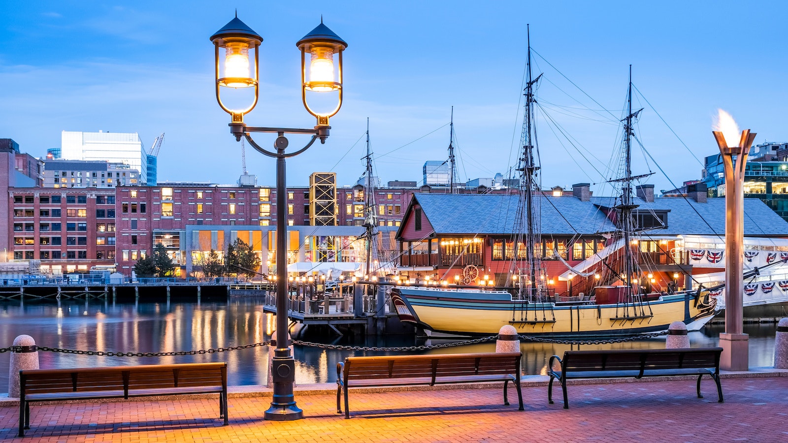 The architecture of Boston in Massachusetts, USA at sunset showcasing the Boston Harbor and Financial District at night.