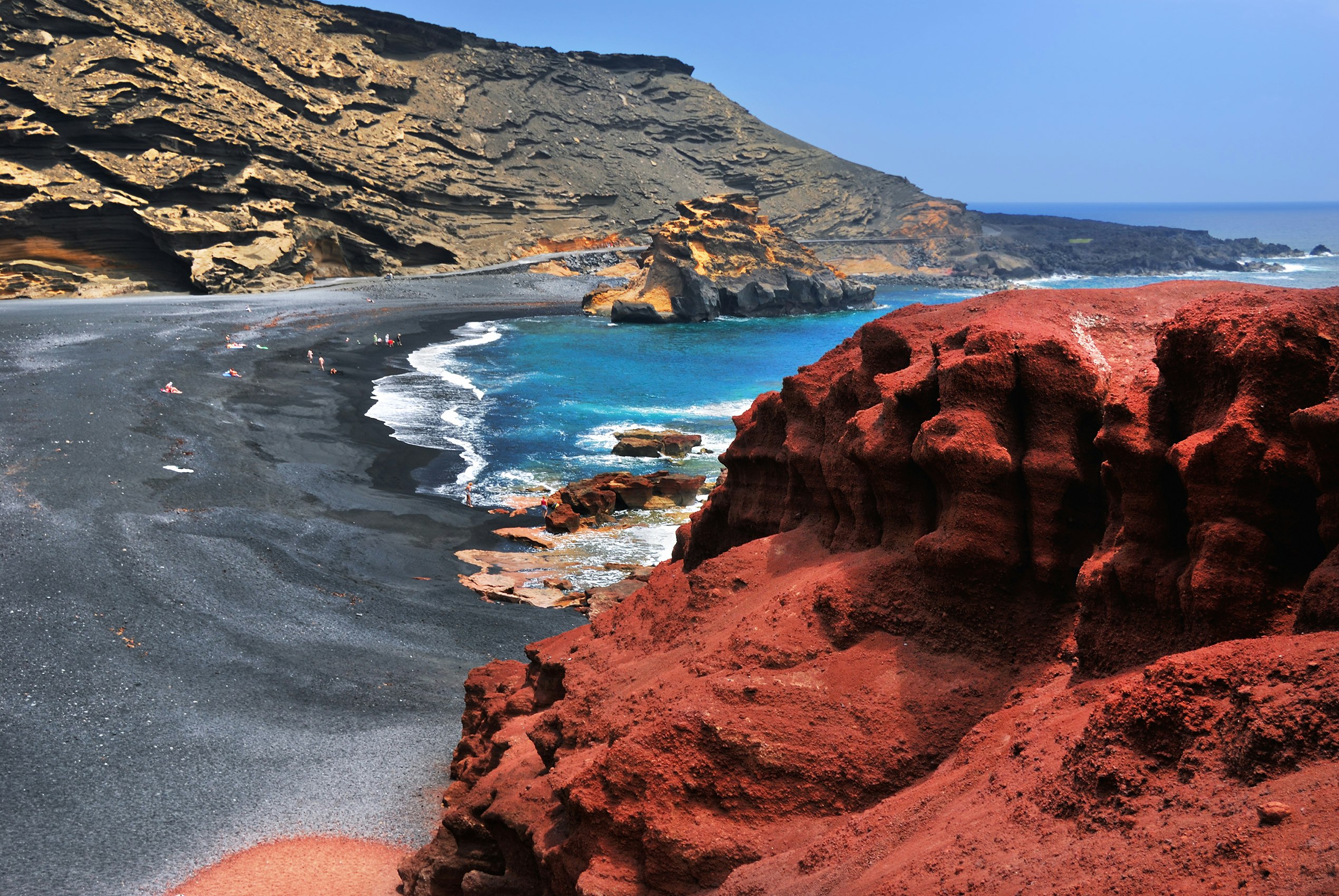 A black-sand beach with vivid red rocks in Lanzarote, Canary Islands