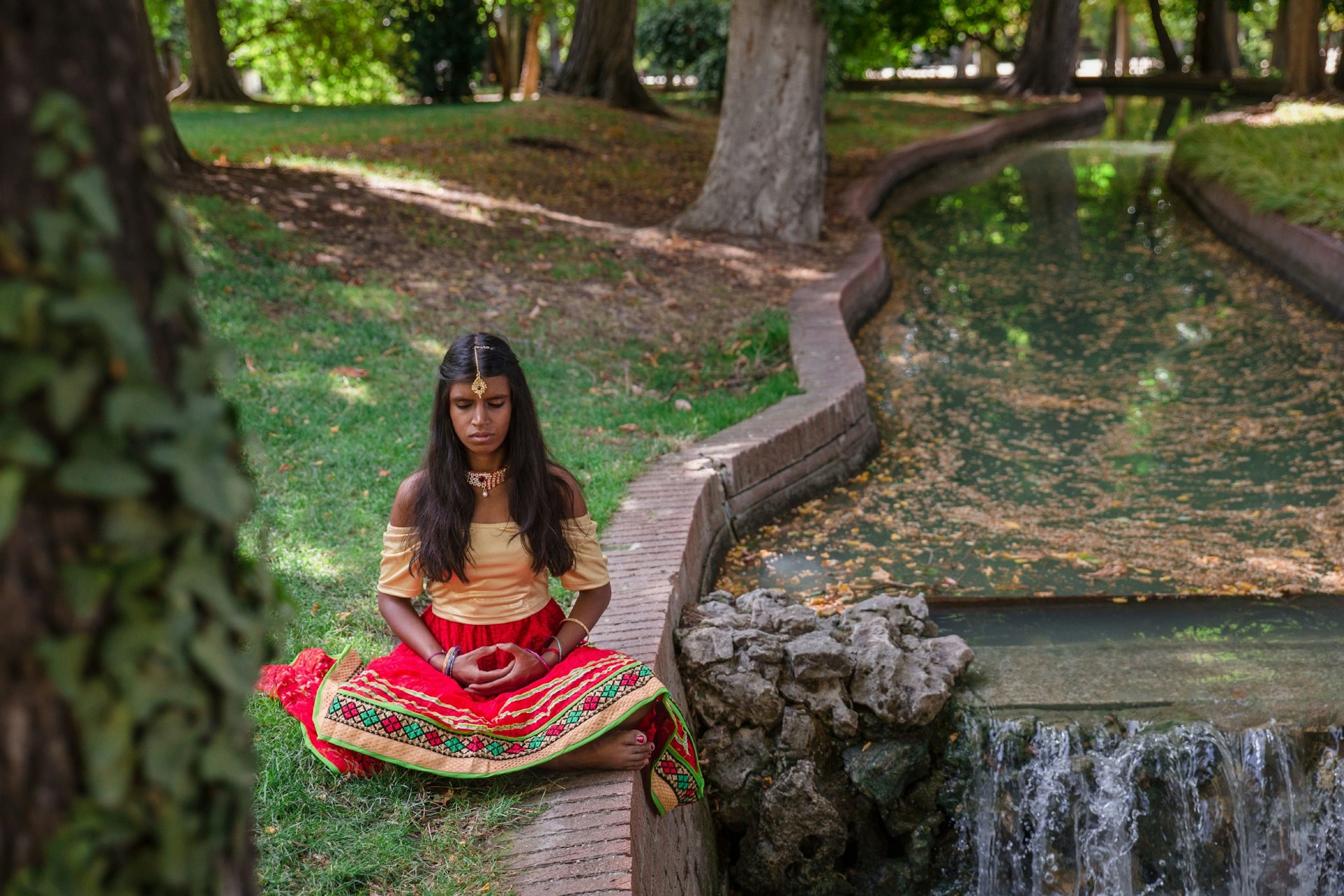 A young Indian woman does yoga outside