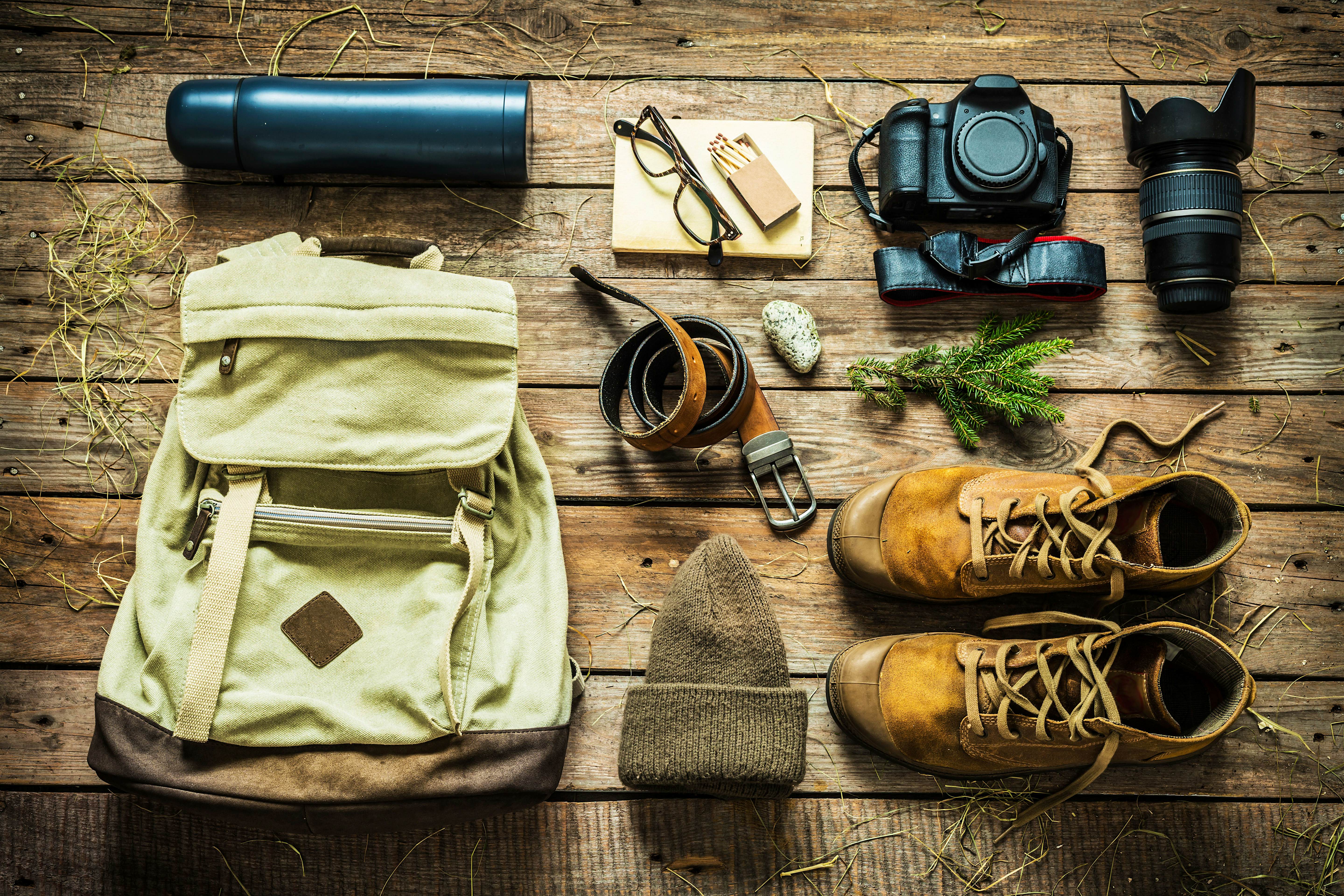 packing-light.jpg Items including boots, a hat, a belt, a thermos and a camera are laid out neatly on a wooden floor, ready to be packed.